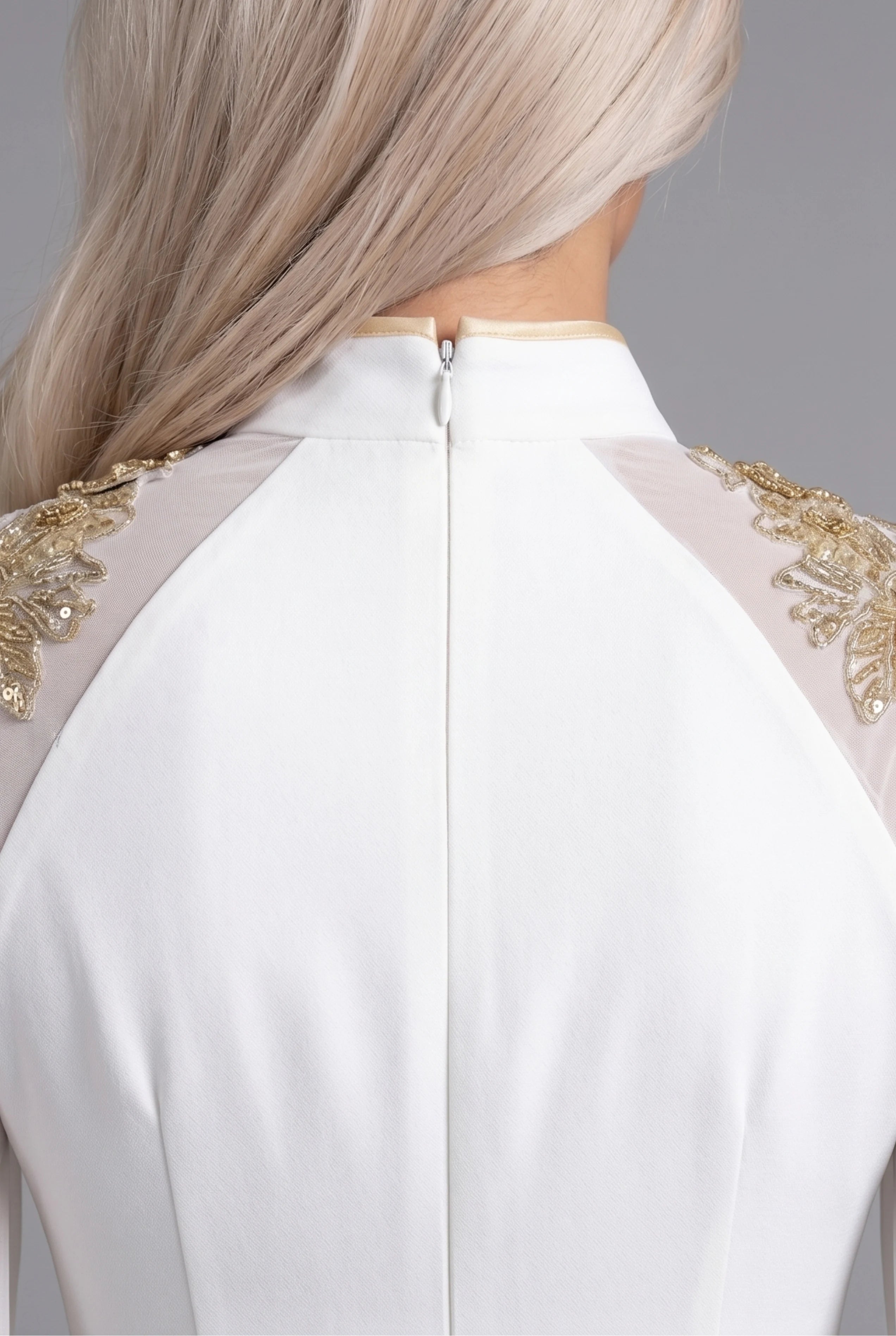 Close-up back view showing the precise hidden zipper closure, high collar structure, and gold lace shoulder panels