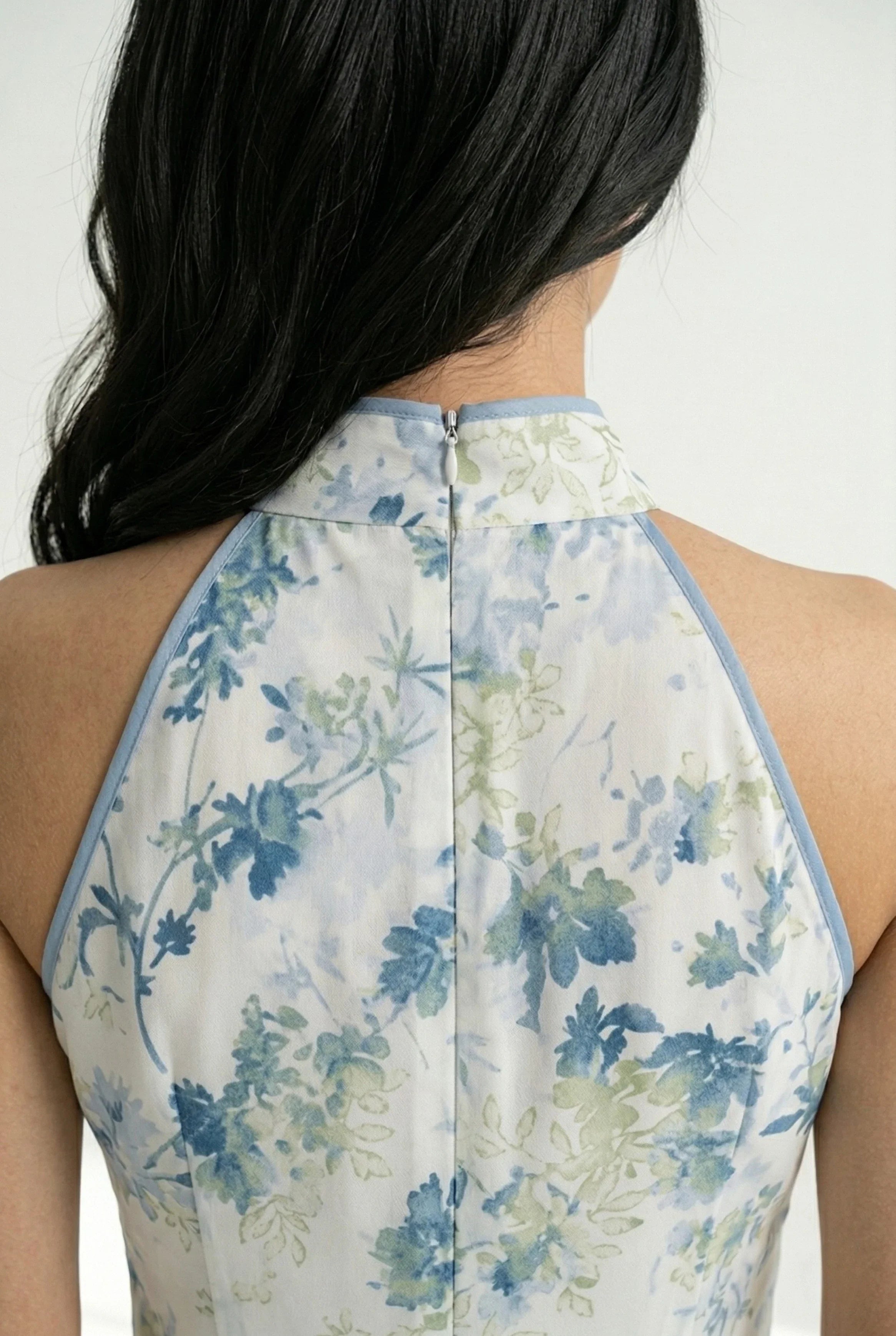 Detail view of the back collar and hidden zipper of the floral cheongsam.