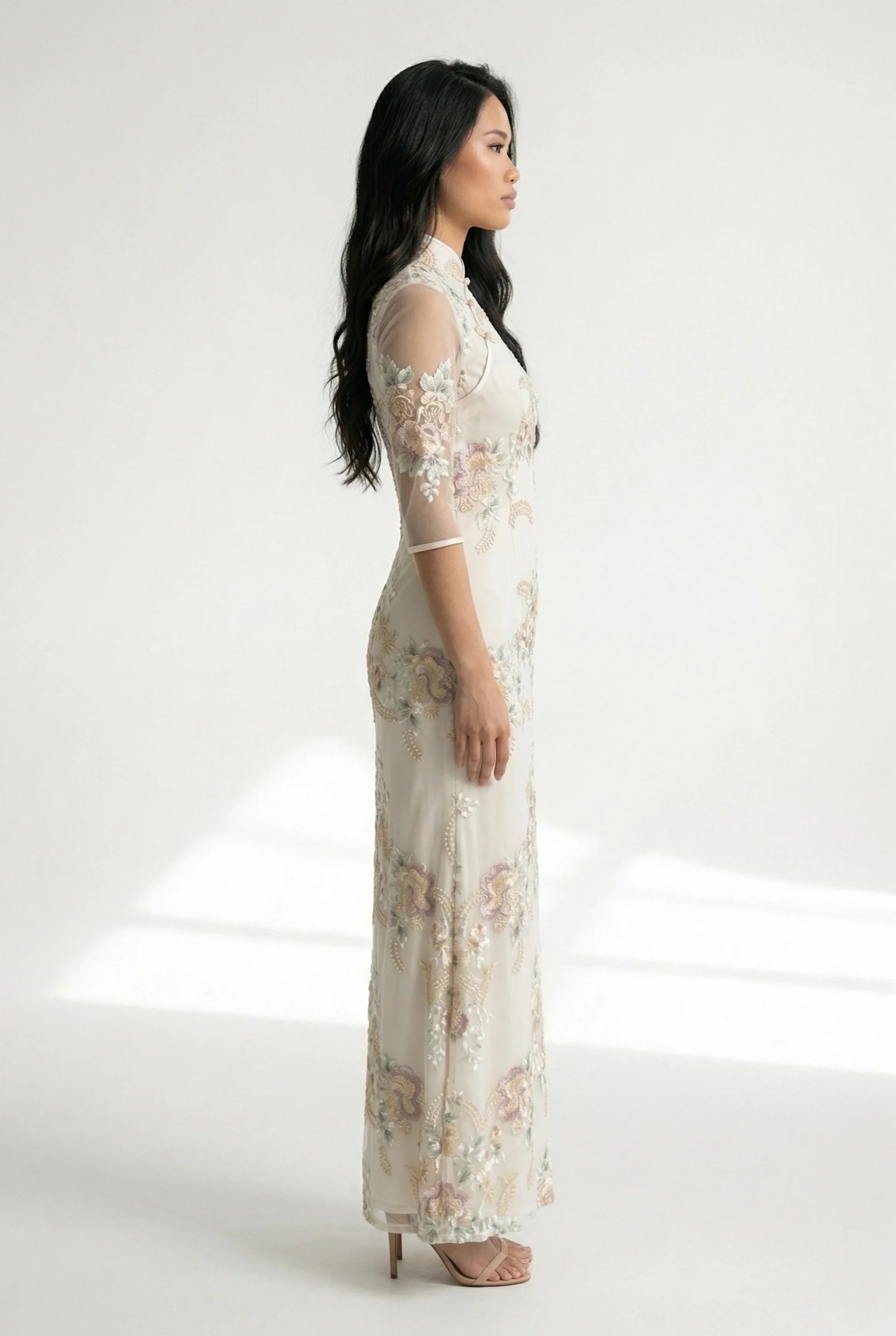 Side profile of the beige Chinese dress with sheer mid-length sleeves.