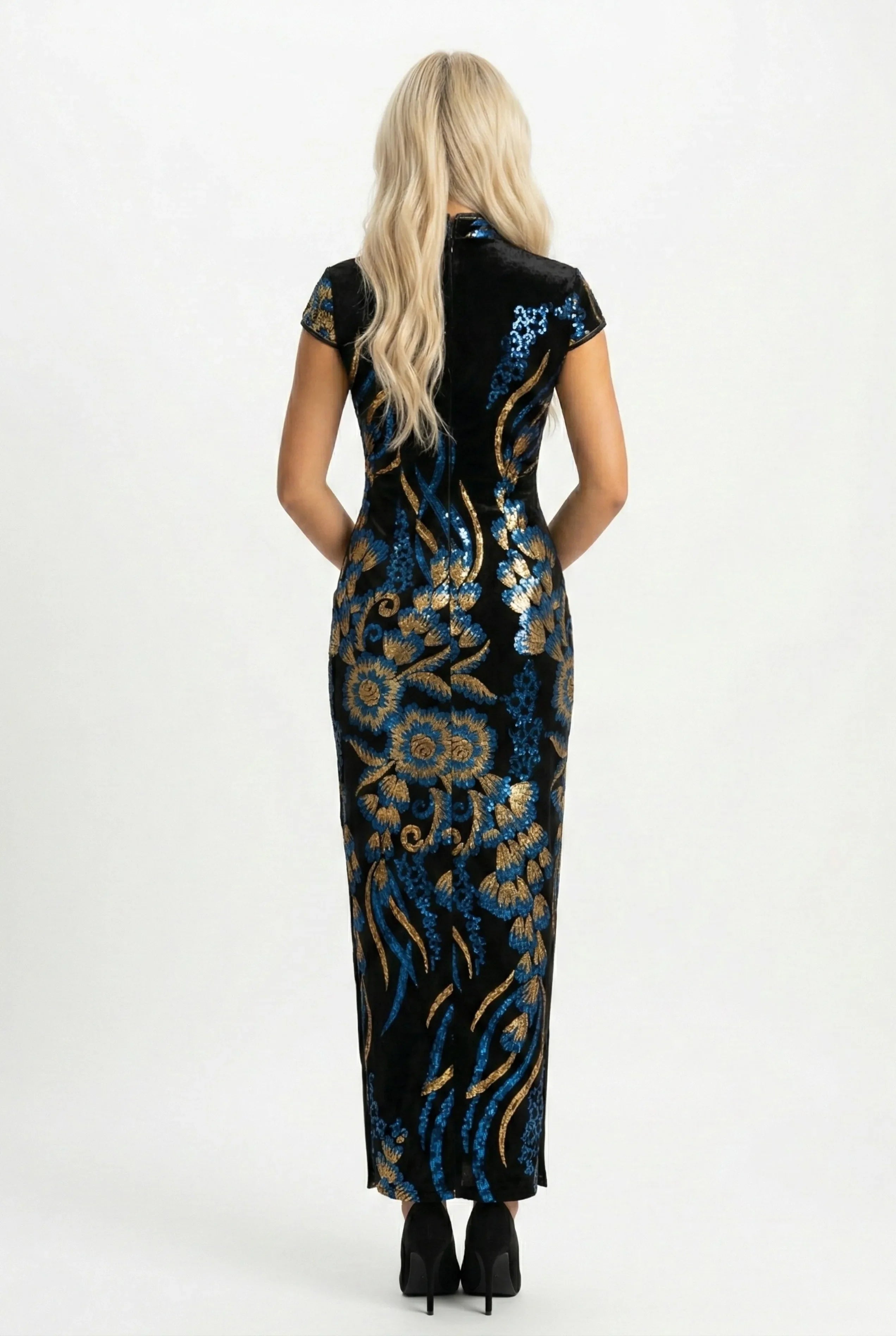 Rear view of a long black velvet qipao dress showing the detailed blue and gold sequin floral pattern and elegant silhouette