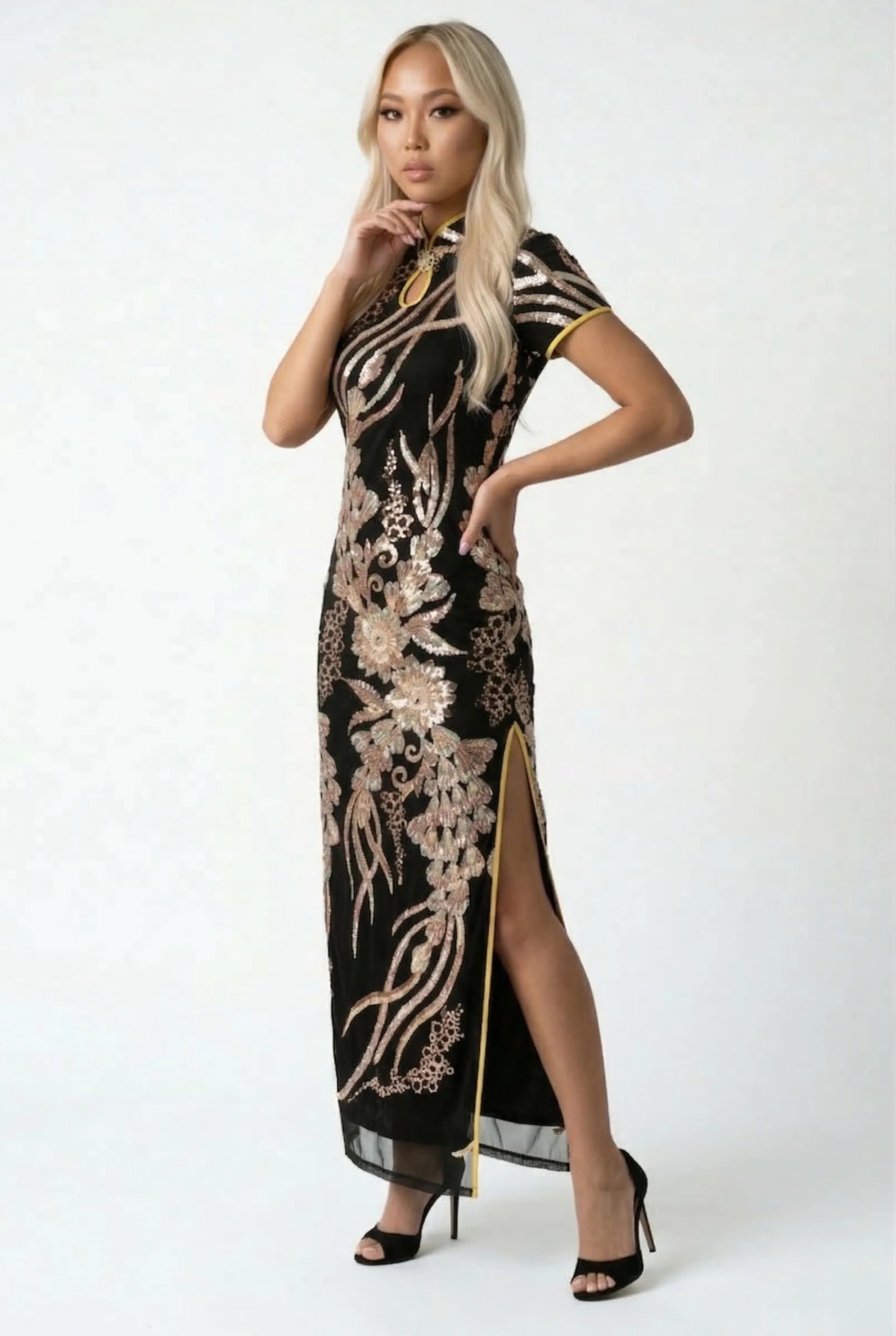 Side view of the black and gold sequin Qipao highlighting the high side slit and yellow contrast lining.
