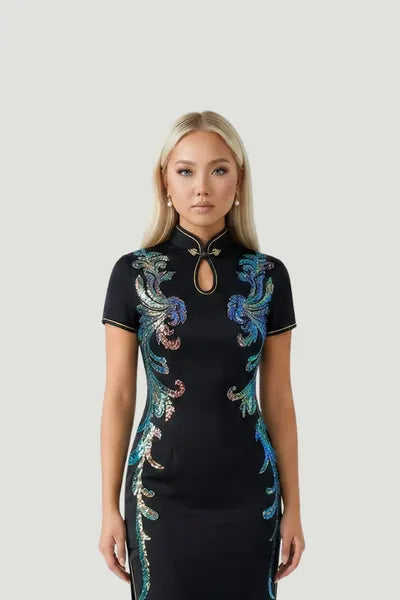 A model wearing a black qipao by Maison Hua, featuring vibrant iridescent embroidery, short sleeves, and a mandarin collar with a keyhole detail
