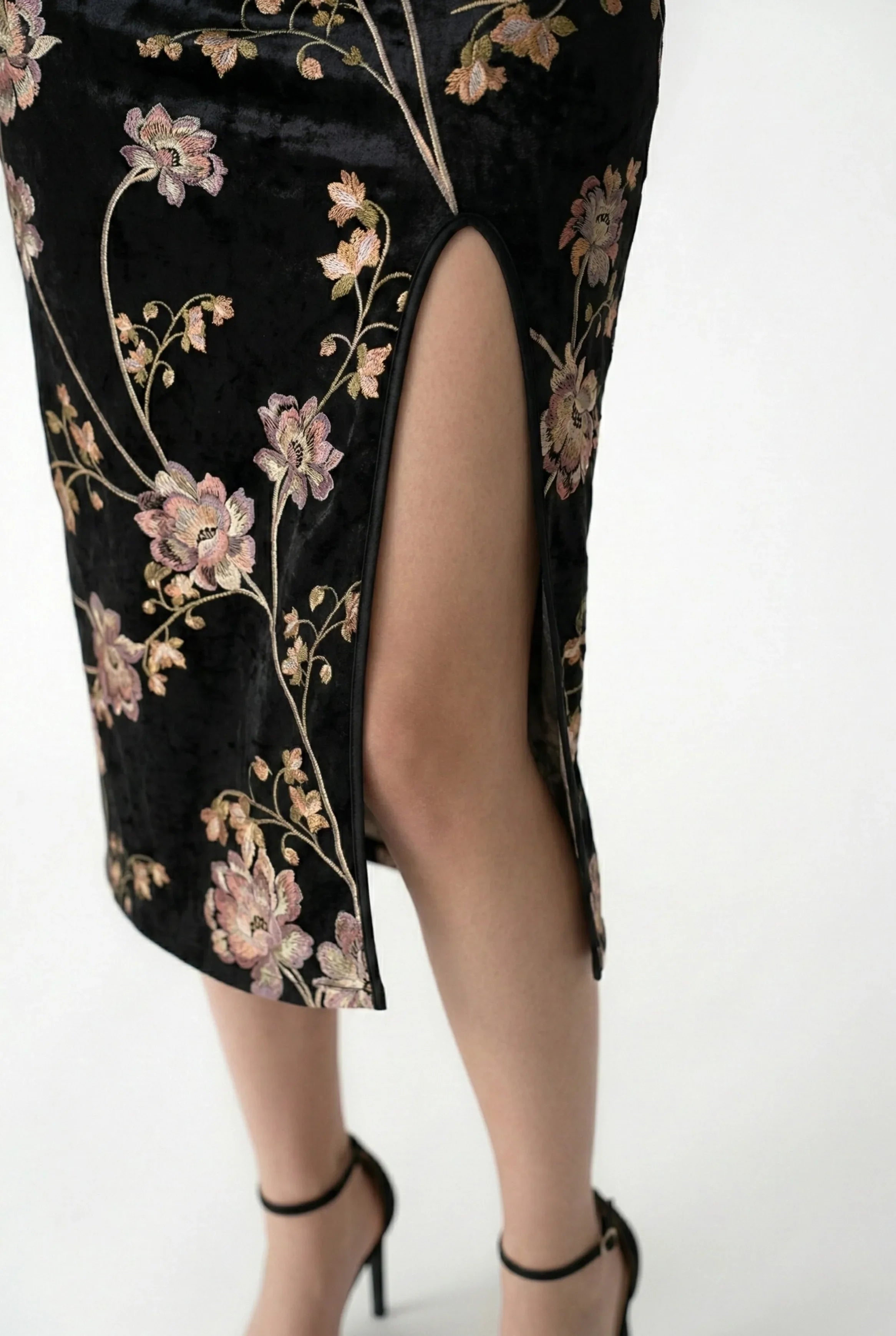 High side slit and floral fabric detail on a modern black qipao