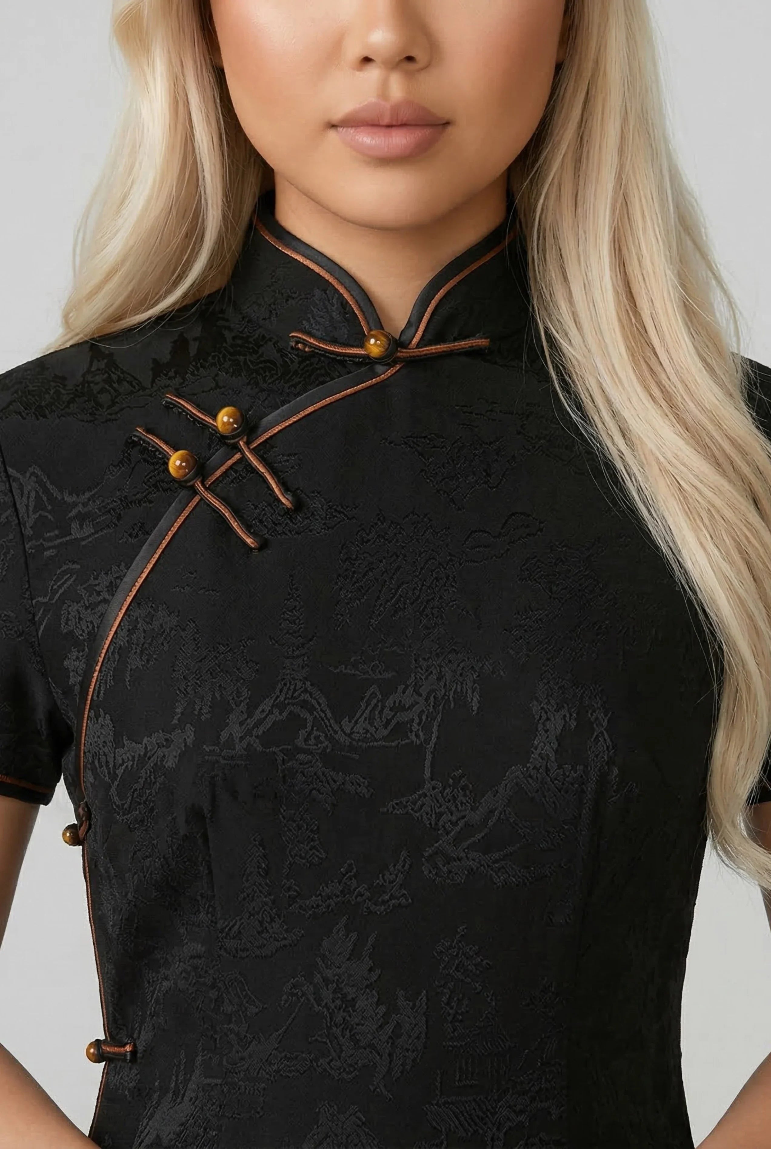 Close-up of the traditional mandarin collar and intricate gold frog button closures on a black silk Qipao.