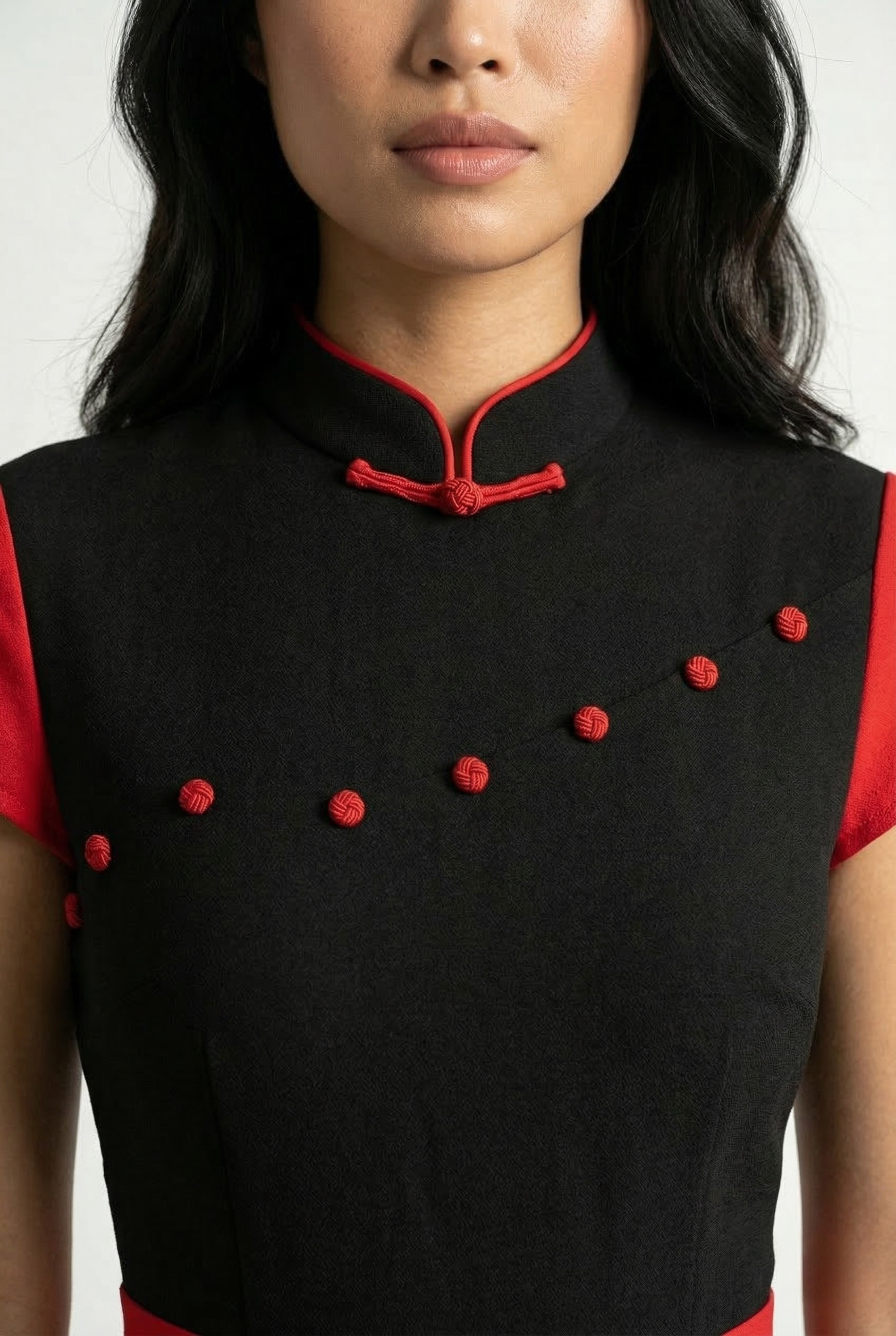 Close-up of the red frog buttons and mandarin collar on a modern black Qipao.