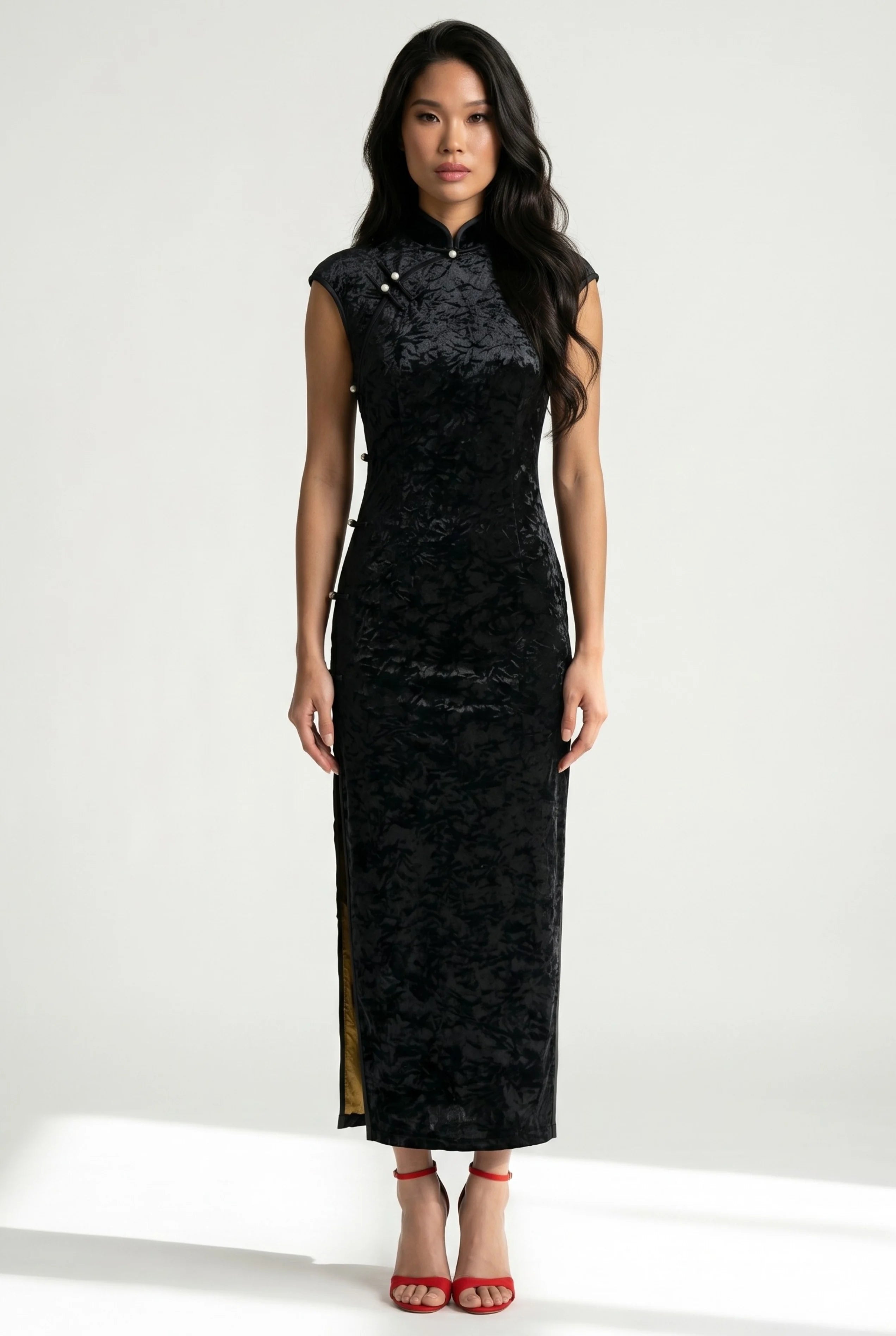 Front view of a sleeveless black velvet cheongsam dress with a high mandarin collar and red strappy heels
