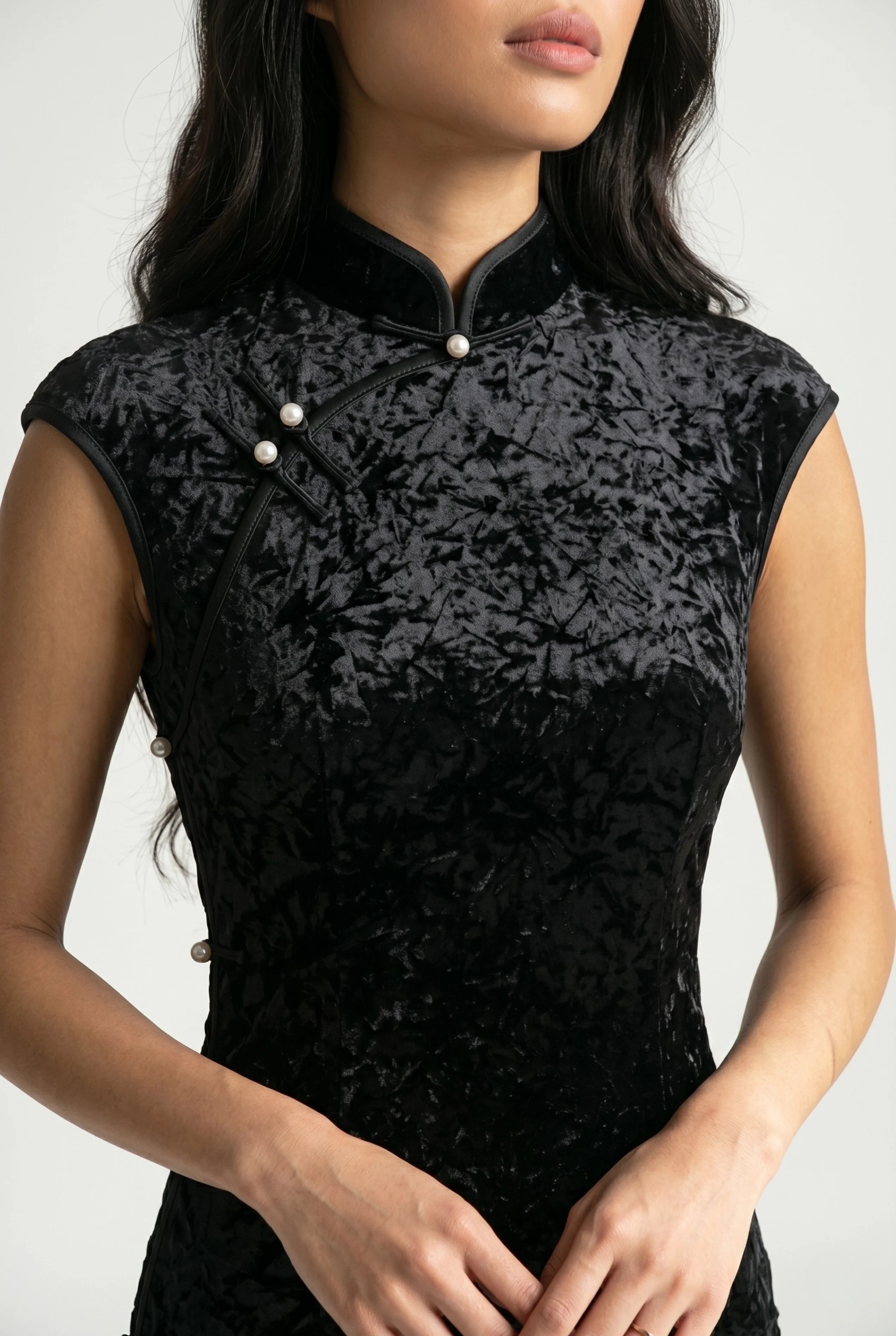 Close-up front view highlighting the textured black velvet bodice, high mandarin collar, and delicate pearl buttons