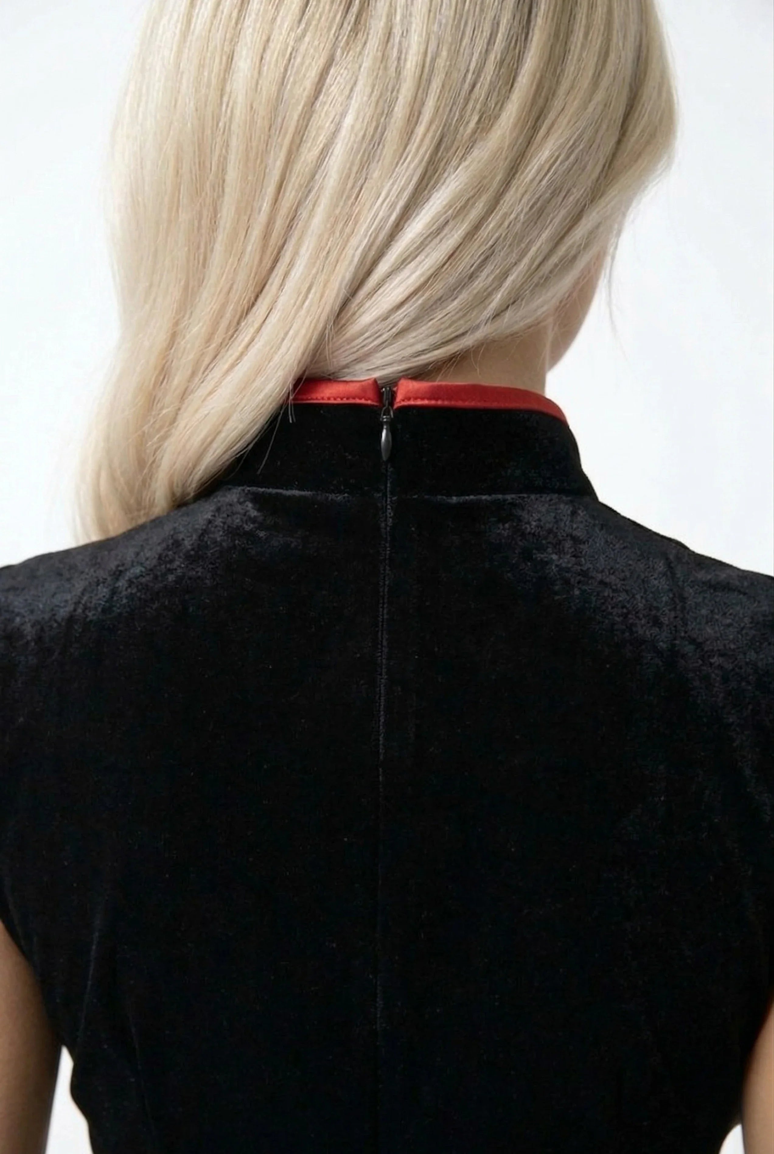 Detailed shot of the high mandarin collar and back zipper on a black velvet Qipao.