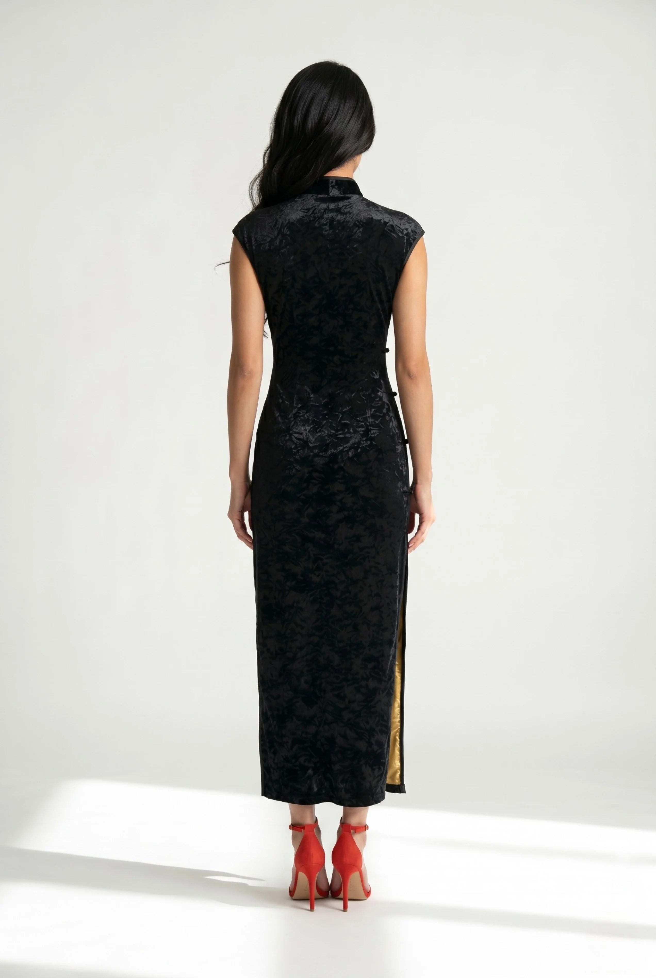 Back view of the ankle-length black velvet cheongsam showcasing its form-fitting tailored silhouette.
