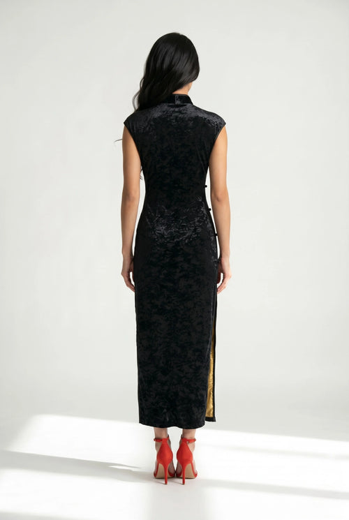 Back view of the ankle-length black velvet cheongsam showcasing its form-fitting tailored silhouette.