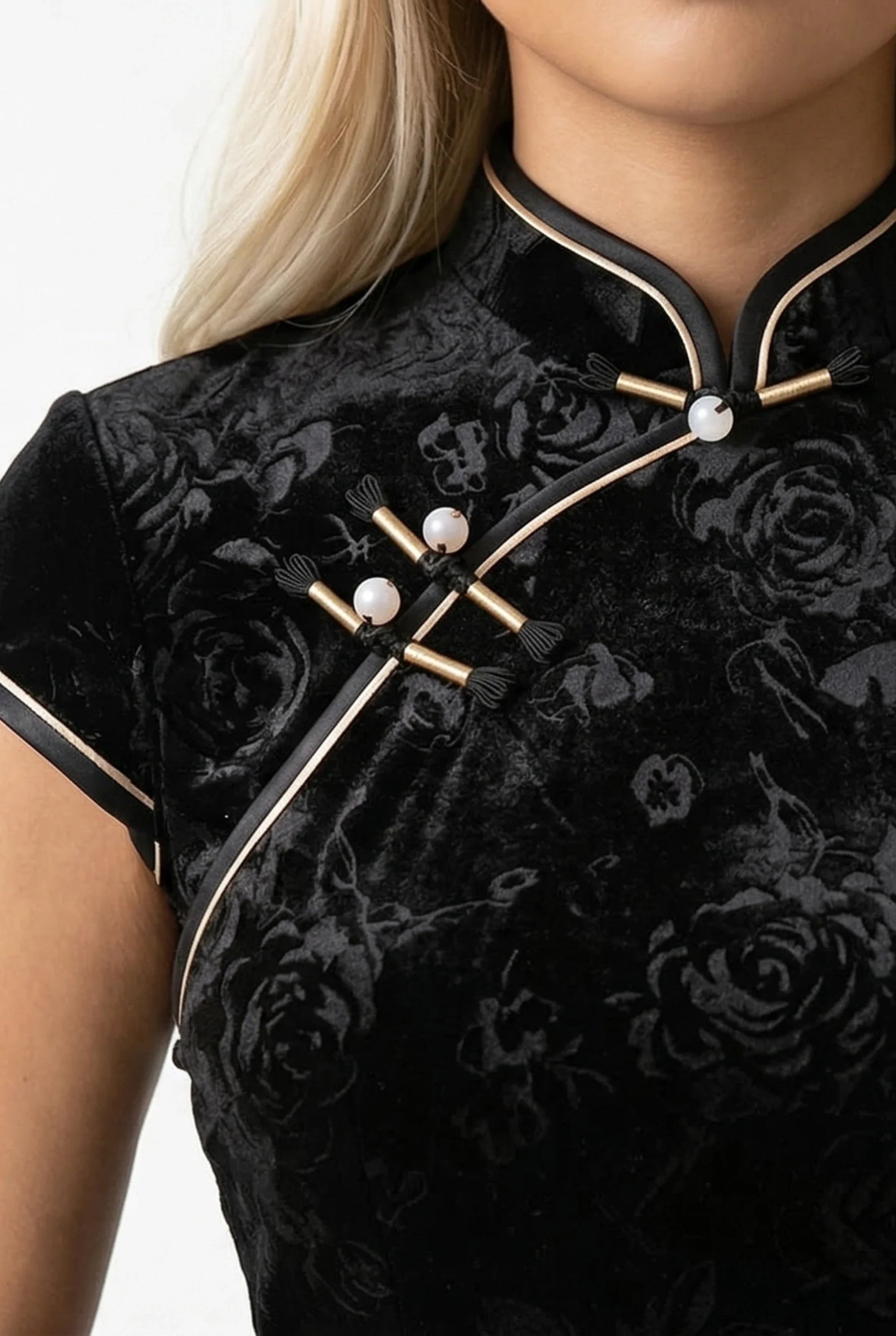 Close-up of the pearl frog buttons and gold trim on the black velvet qipao.