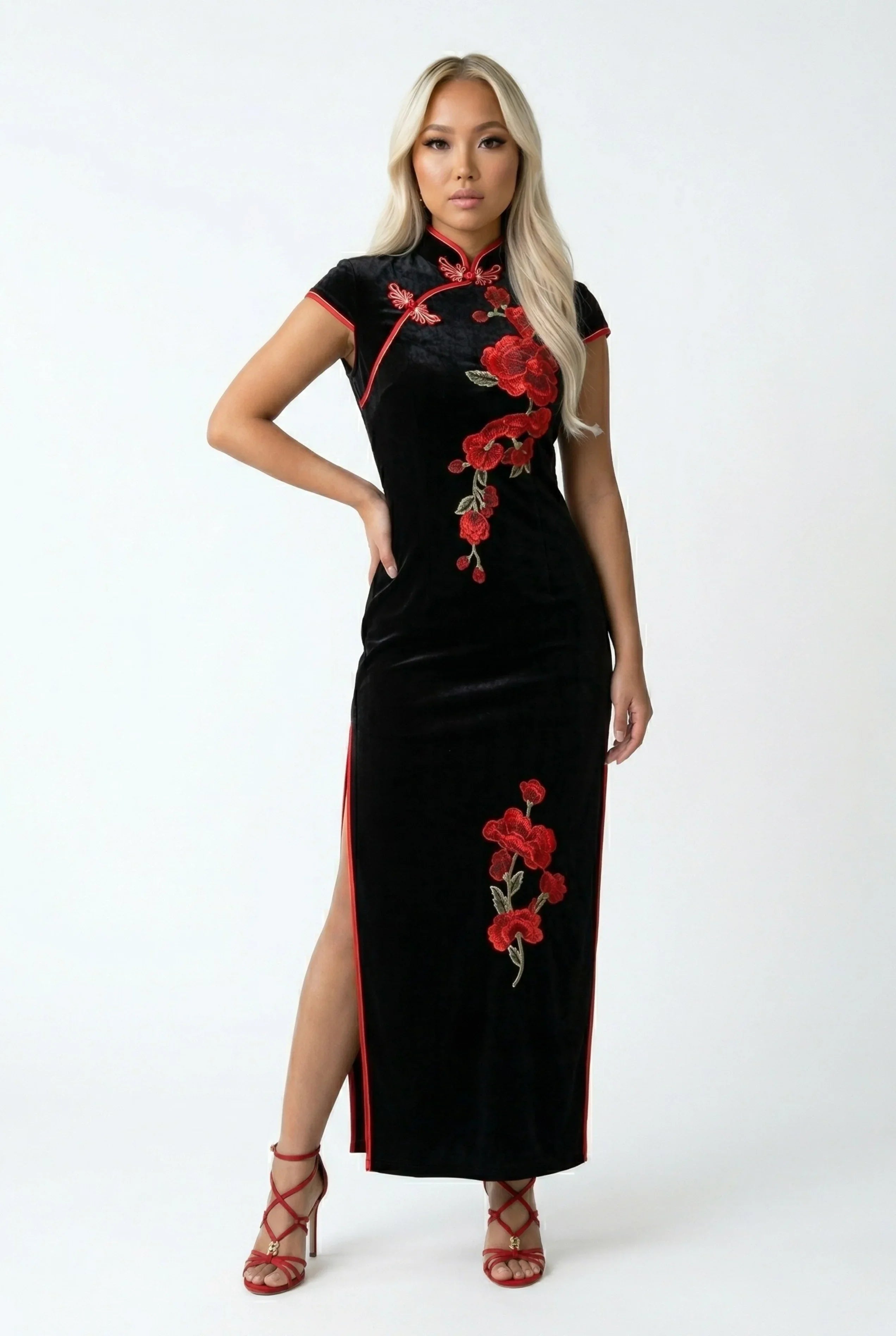 Full-length front view of a black velvet Qipao with red floral embroidery and red piping.