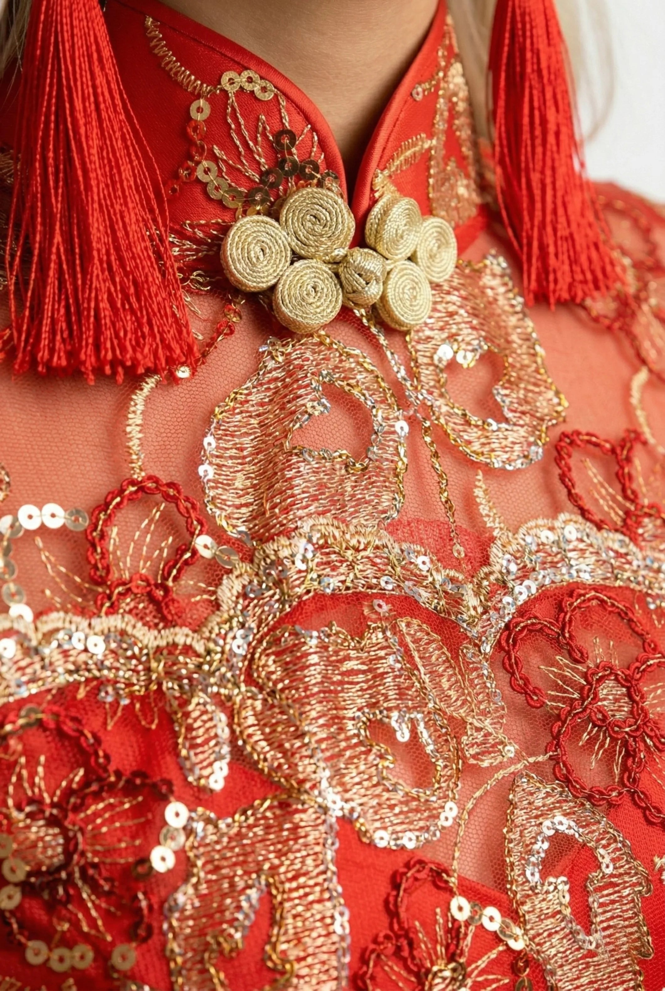 Detail of gold pankou button and decorative red tassels