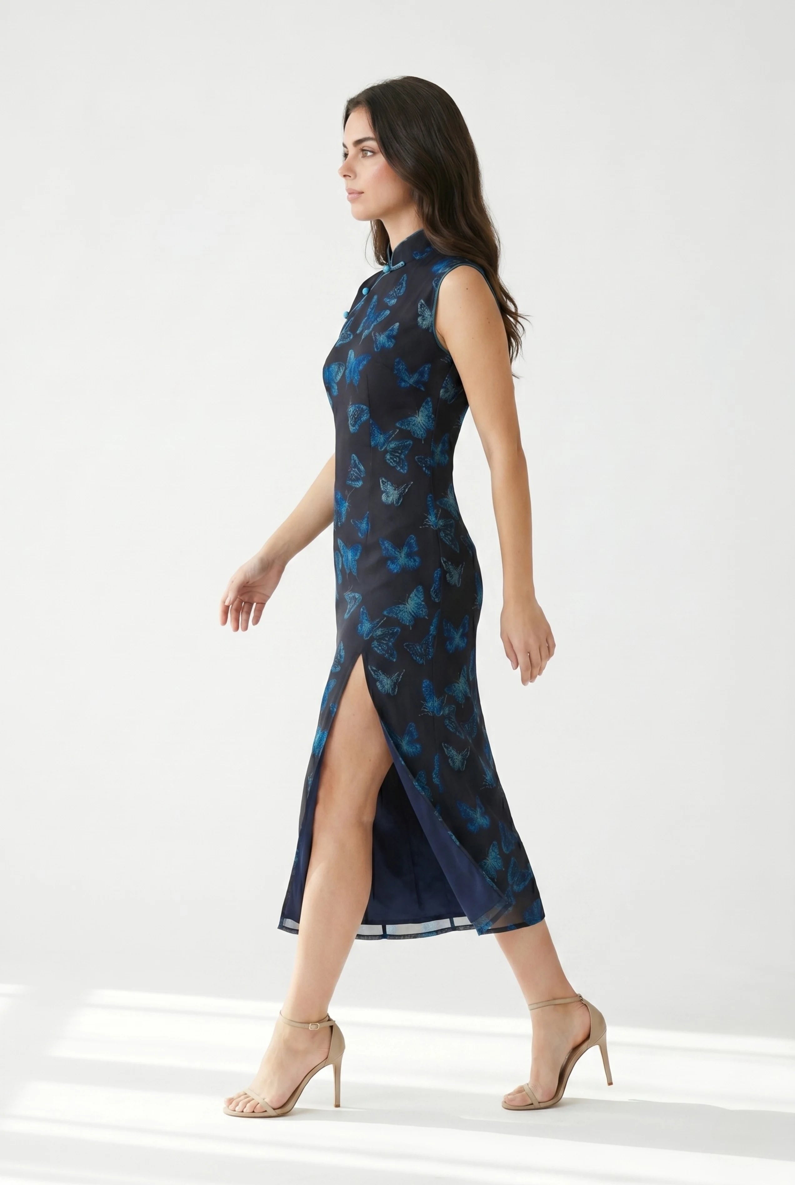 Side profile view of a woman walking in the light green butterfly dress, showcasing the high side slit