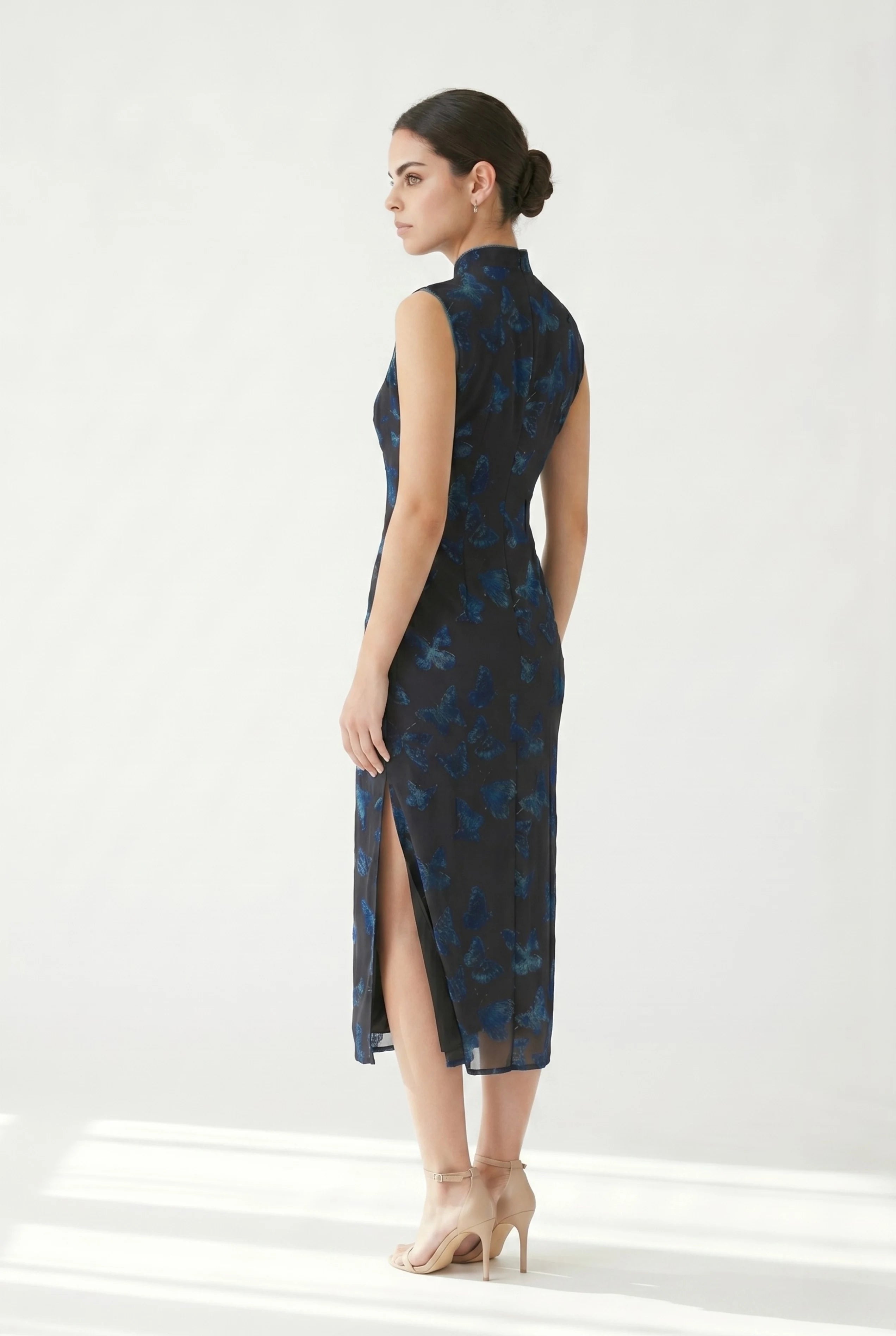 Three-quarter back profile view highlighting the sleek silhouette of the green butterfly qipao dress