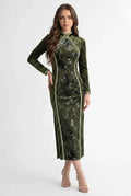 Front full-length view of a long sleeve olive green velvet Chinese dress featuring elegant contrast piping