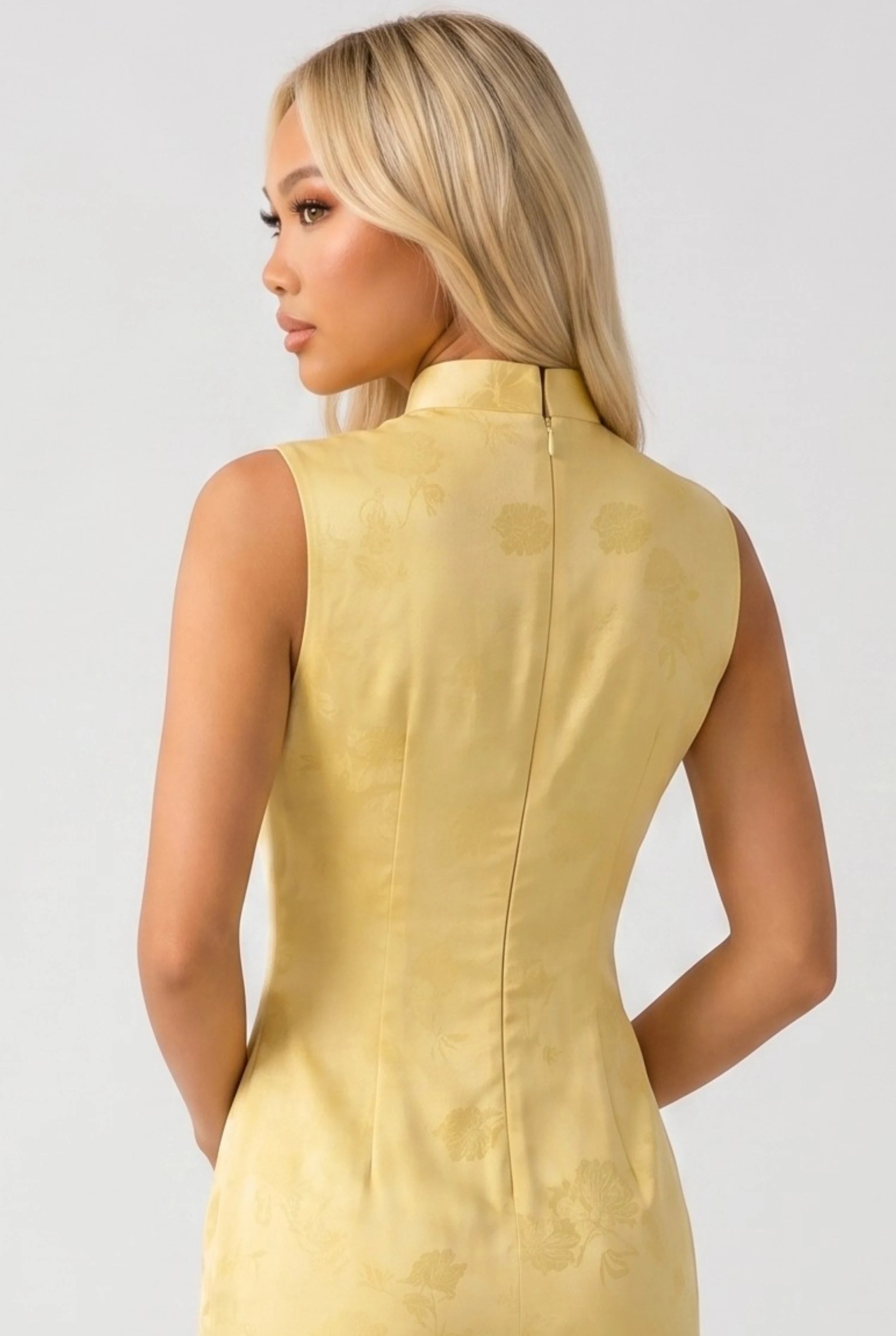 Close-up back view showing the hidden zipper closure and high mandarin collar of the yellow qipao