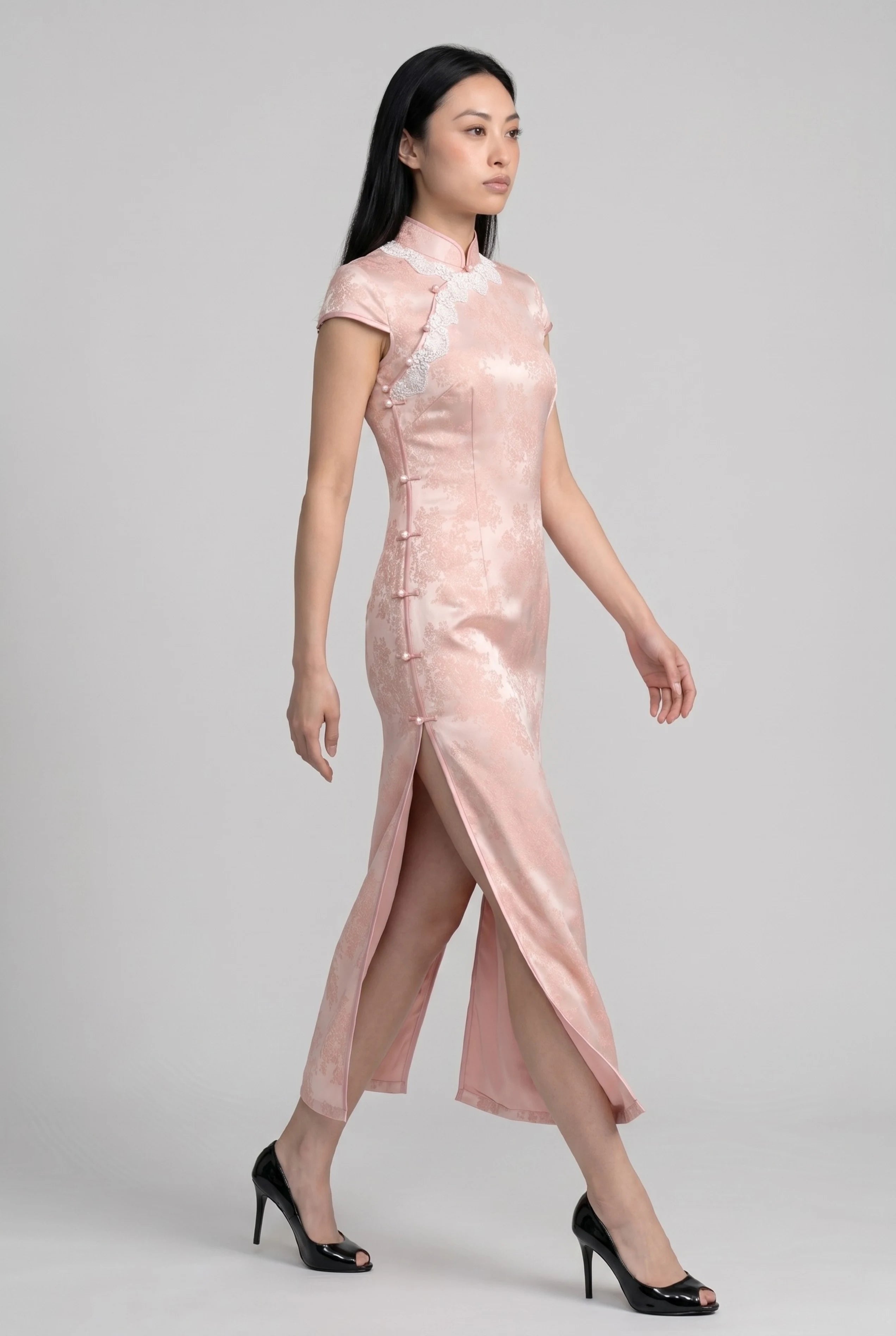 Side profile view of a woman walking in the pink Chinese style dress, showcasing the high side slit
