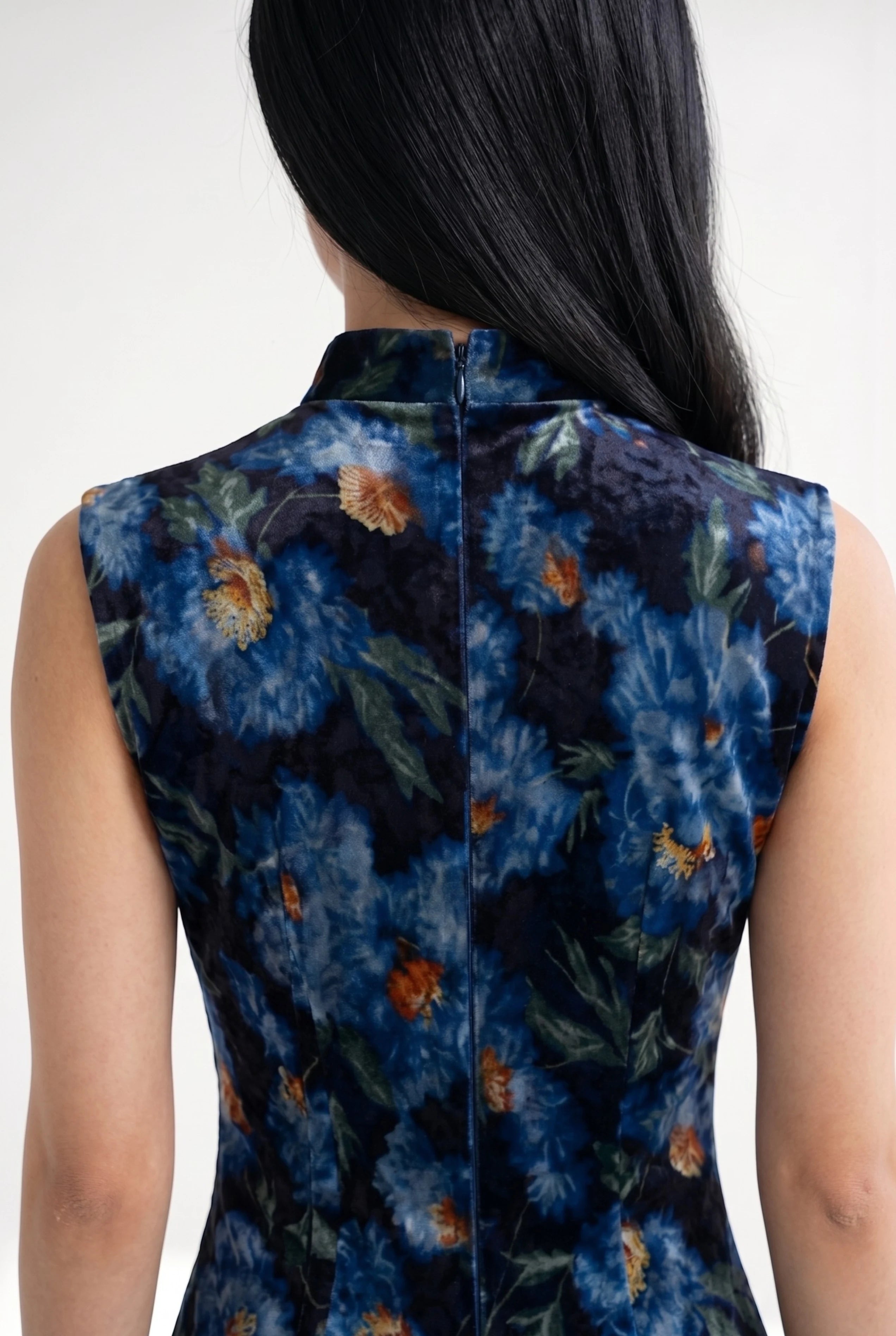 Close-up back view showing the high collar structure and hidden zipper closure of the velvet Chinese dress