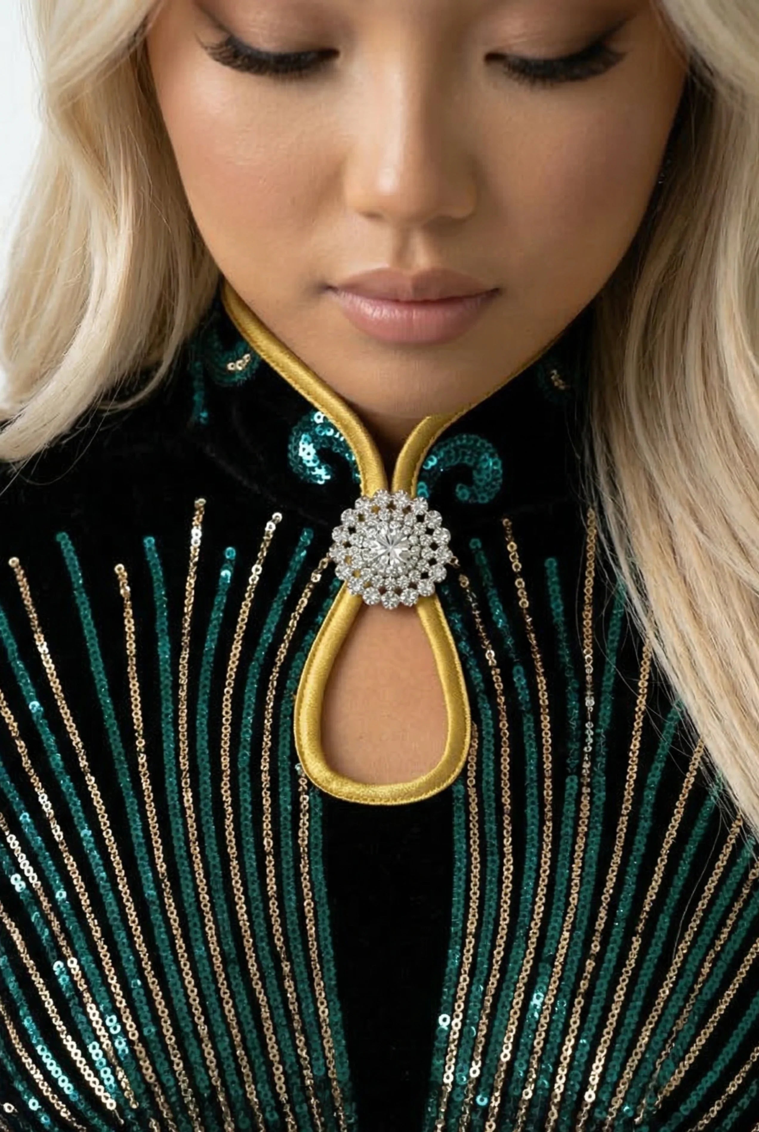 Detailed close-up of the back mandarin collar of a dark green Qipao and a floral hair accessory.