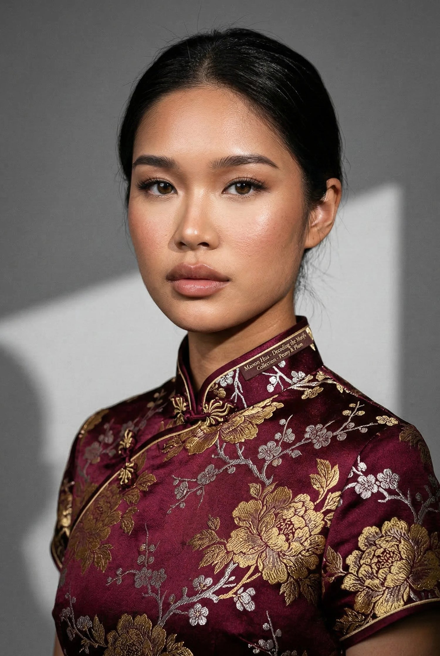 Burgundy Qipao Chinese dress featuring gold peony and plum blossom motifs in high-density brocade silk