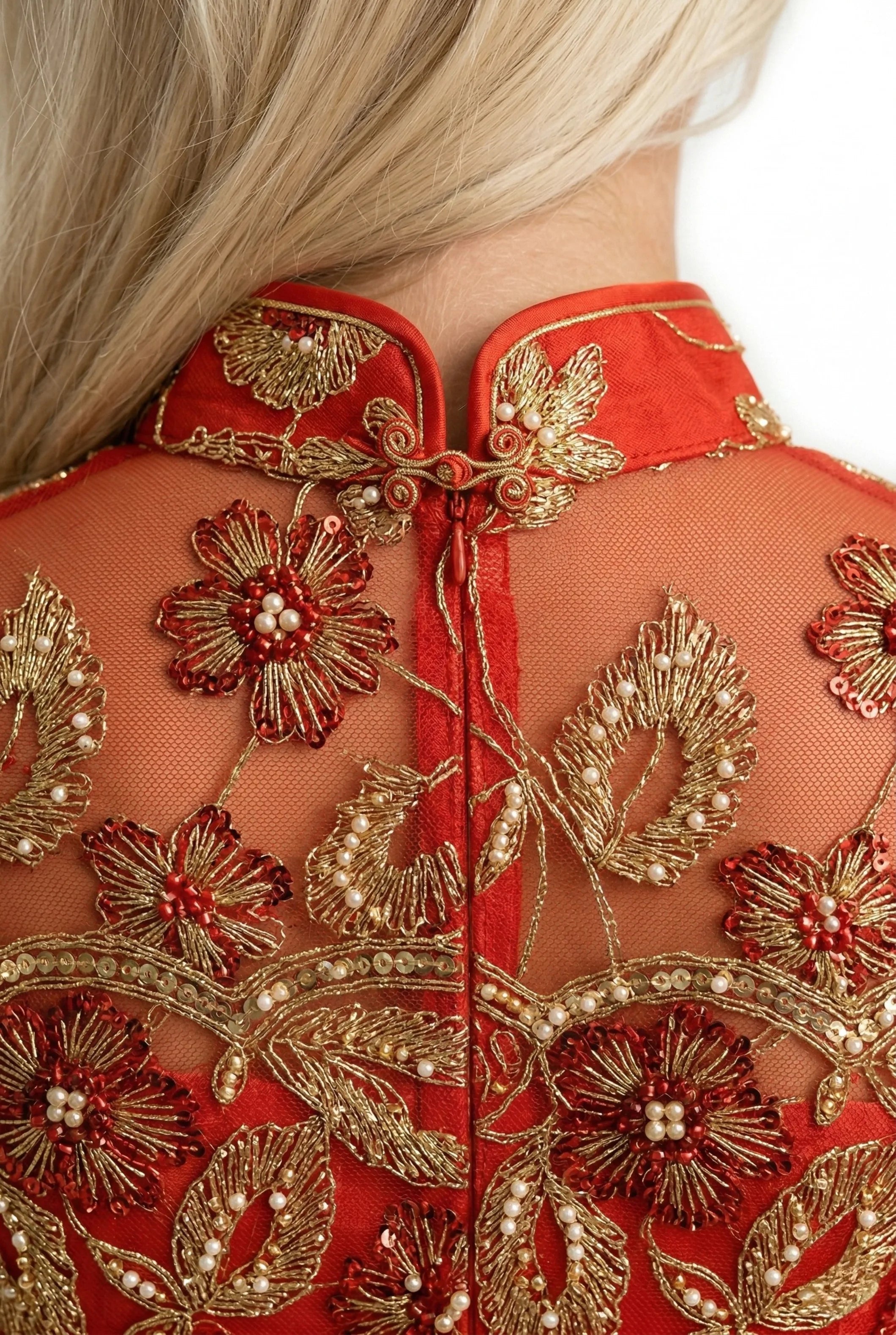 Gold floral embroidery on the back of a red cheongsam collar.
