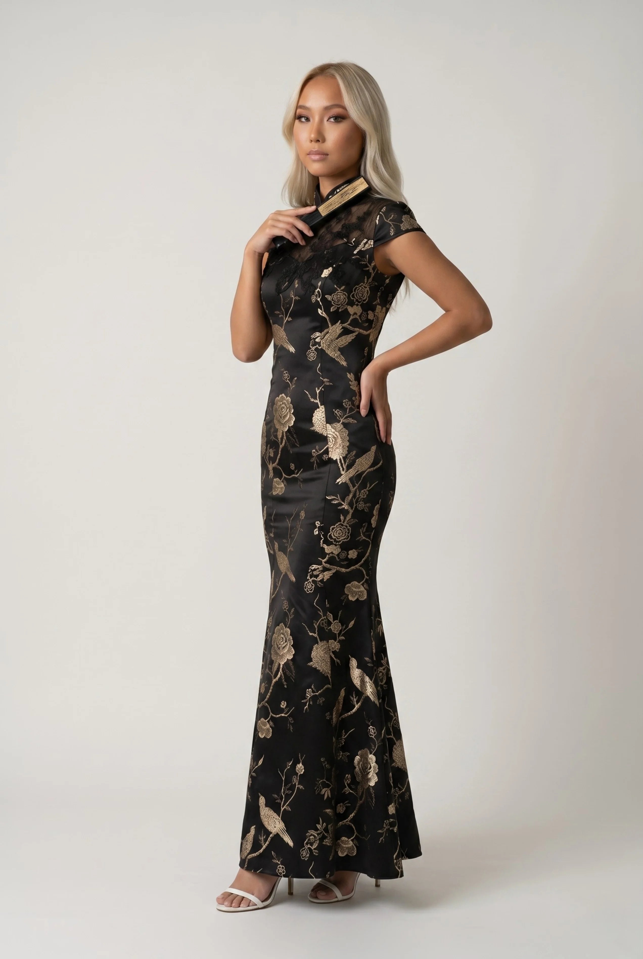 Full-length view of the elegant black and gold Chinese gown, showcasing the elaborate traditional pattern