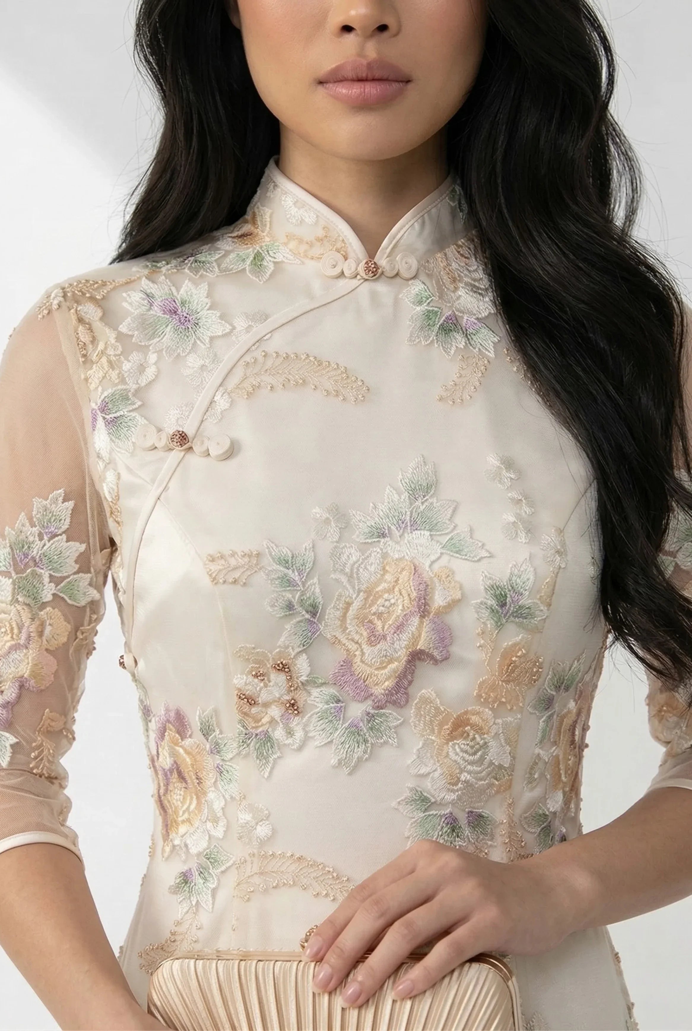 Close-up of the intricate floral embroidery on the beige qipao.