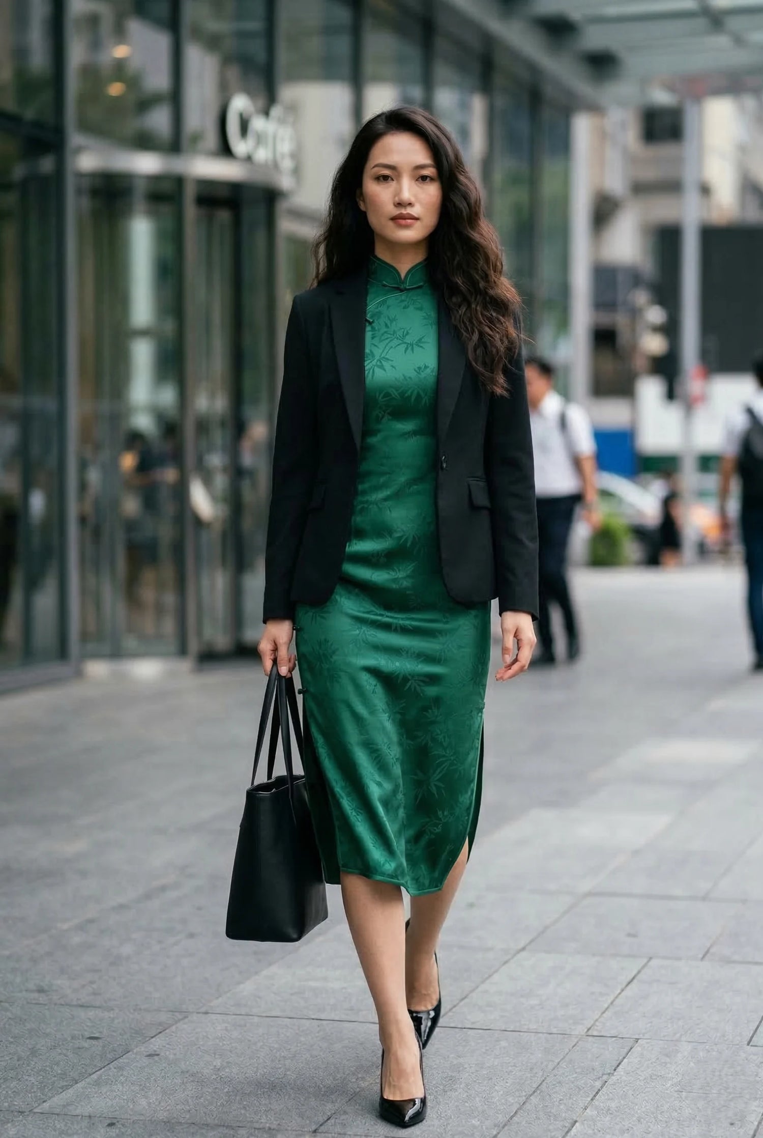 Emerald green silk qipao styled with a black blazer and leather tote bag by Maison Hua, demonstrating professional urban wear and maintenance tips for heritage textiles