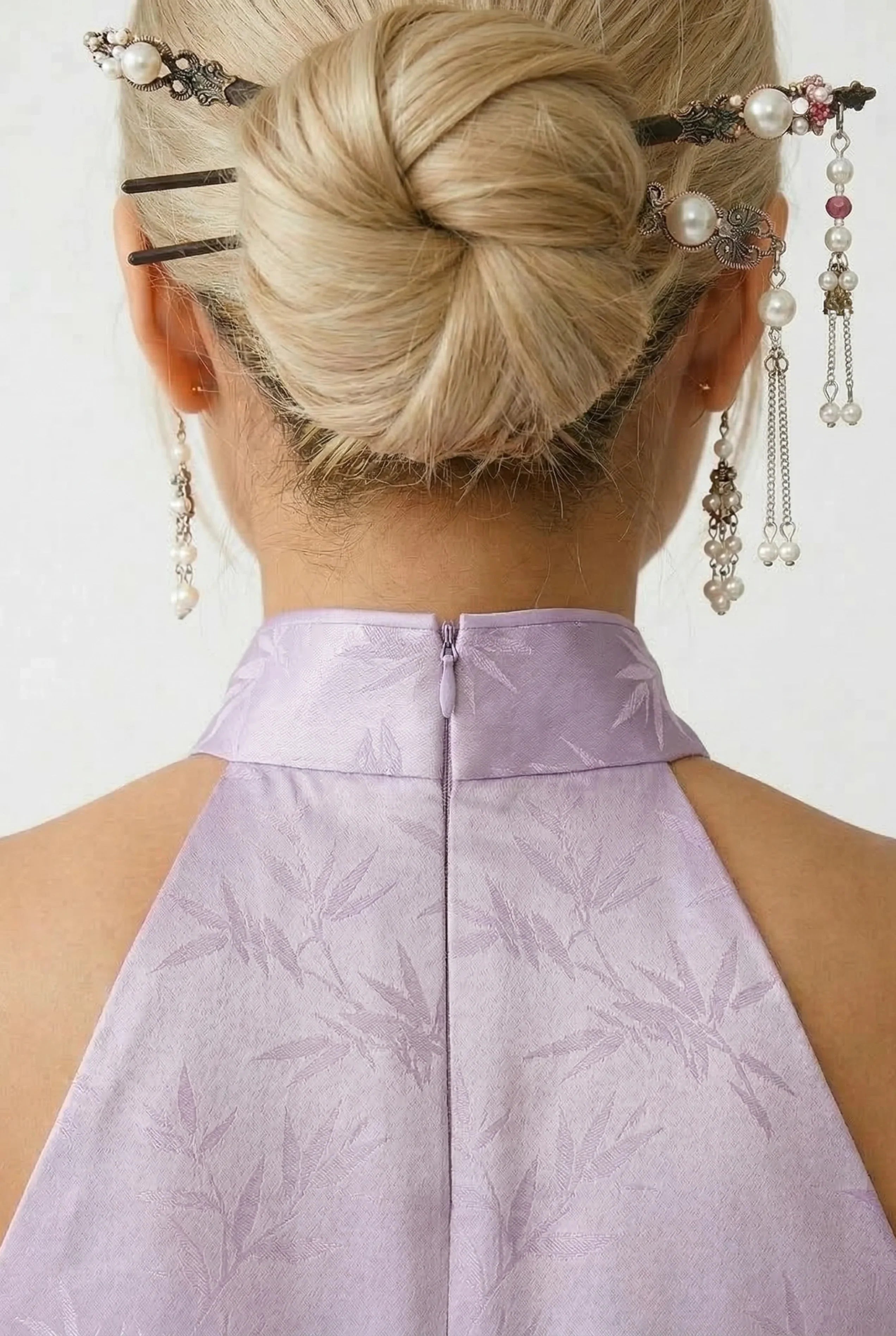 Detailed shot of the high back collar and halter design on a lavender Chinese dress with traditional hair accessories.