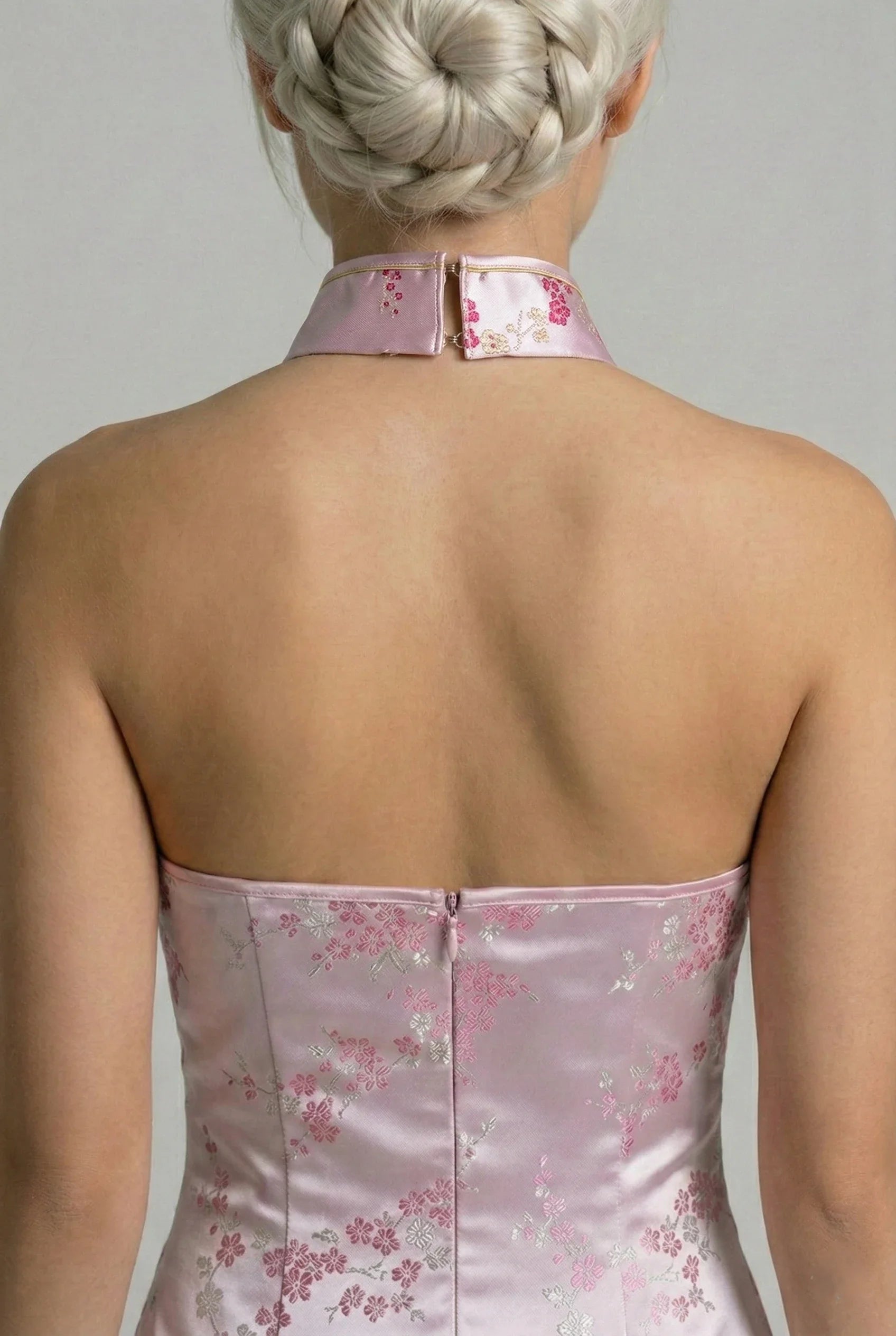 Close-up of the back neck closure on a halter-style pink floral qipao