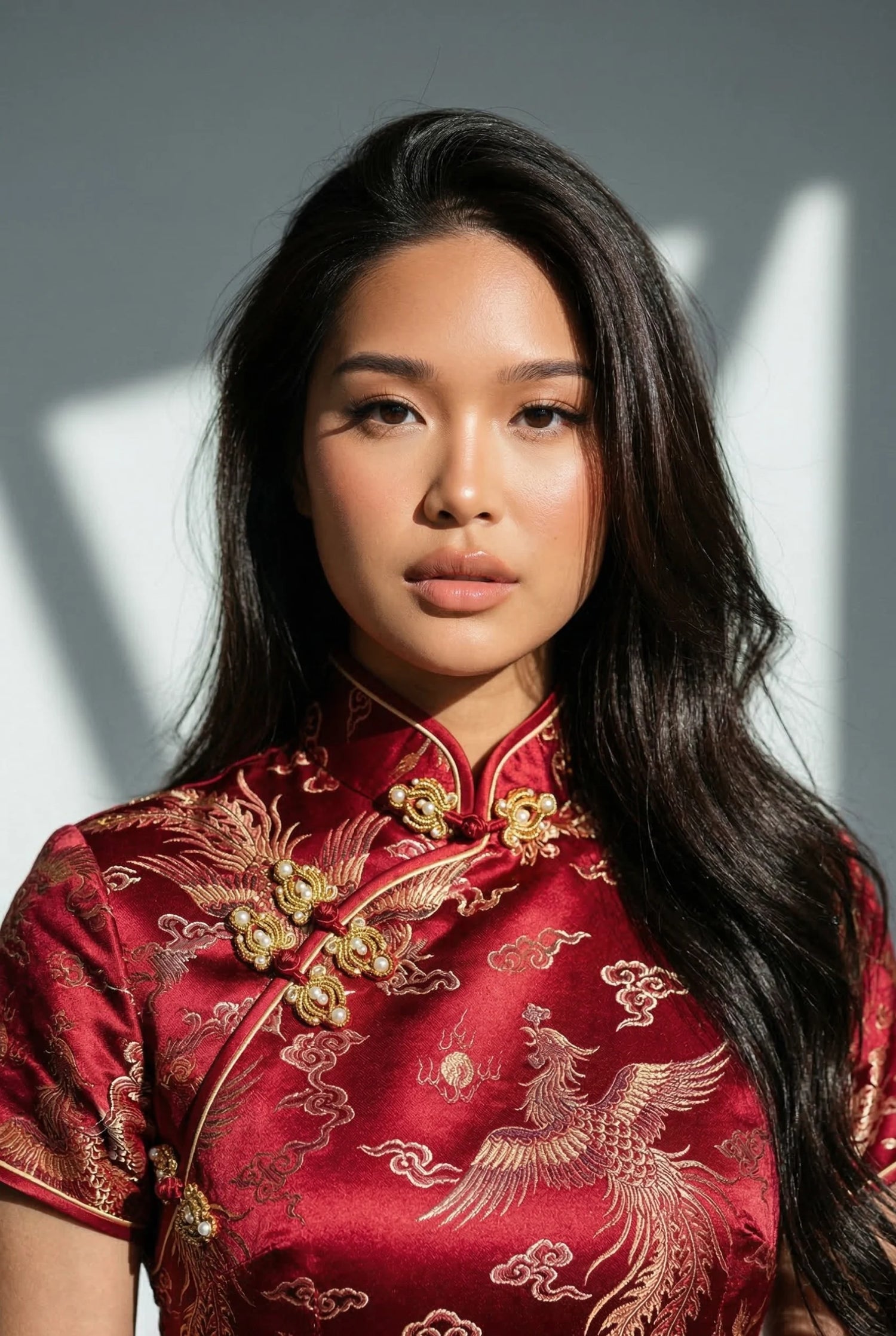 Close-up of a high-quality traditional red Chinese wedding dress with intricate gold phoenix embroidery, showcasing a rigid Mandarin collar and Pankou closures