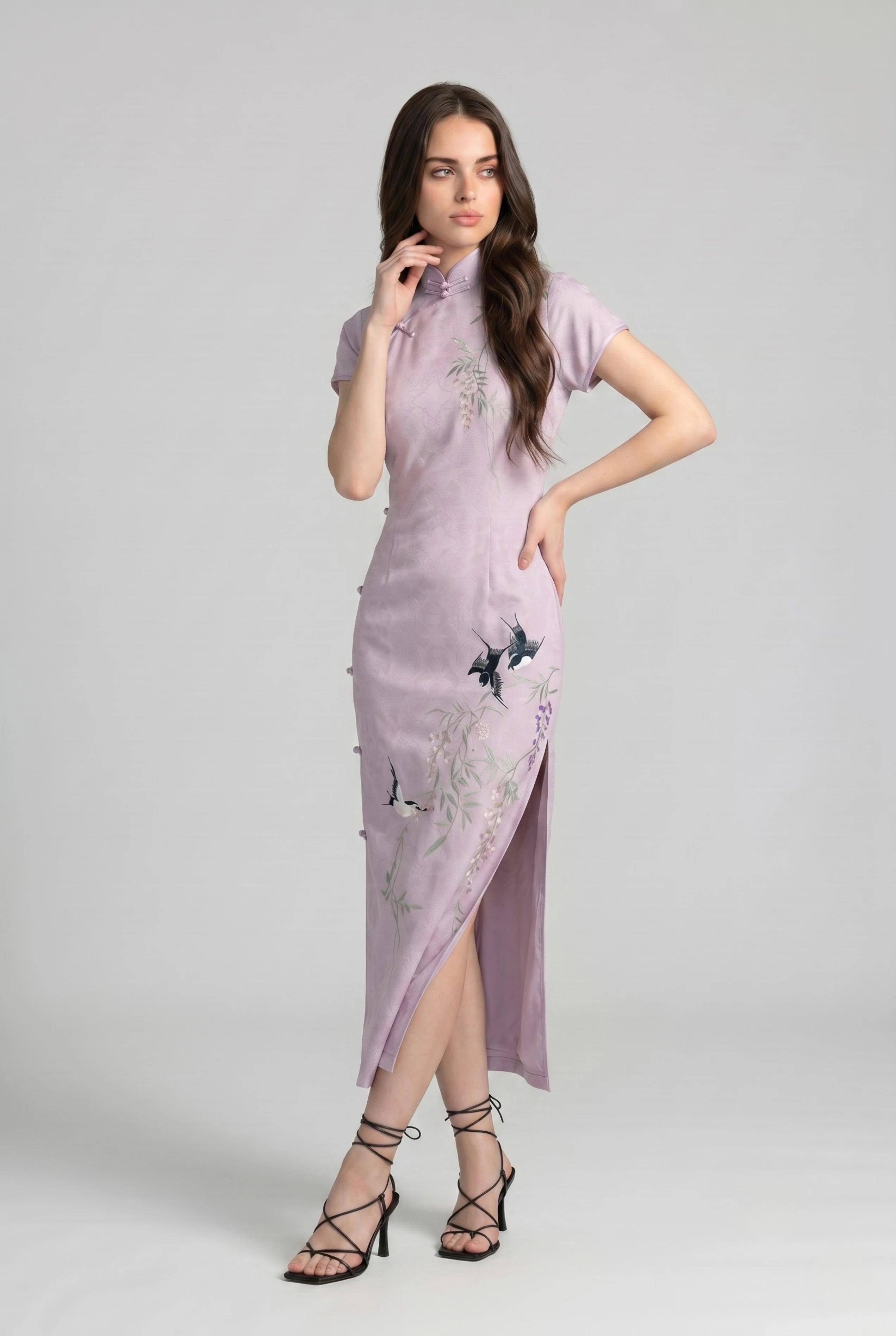 Three-quarter front view of the lavender qipao dress highlighting the elegant side slit and embroidered bird patterns