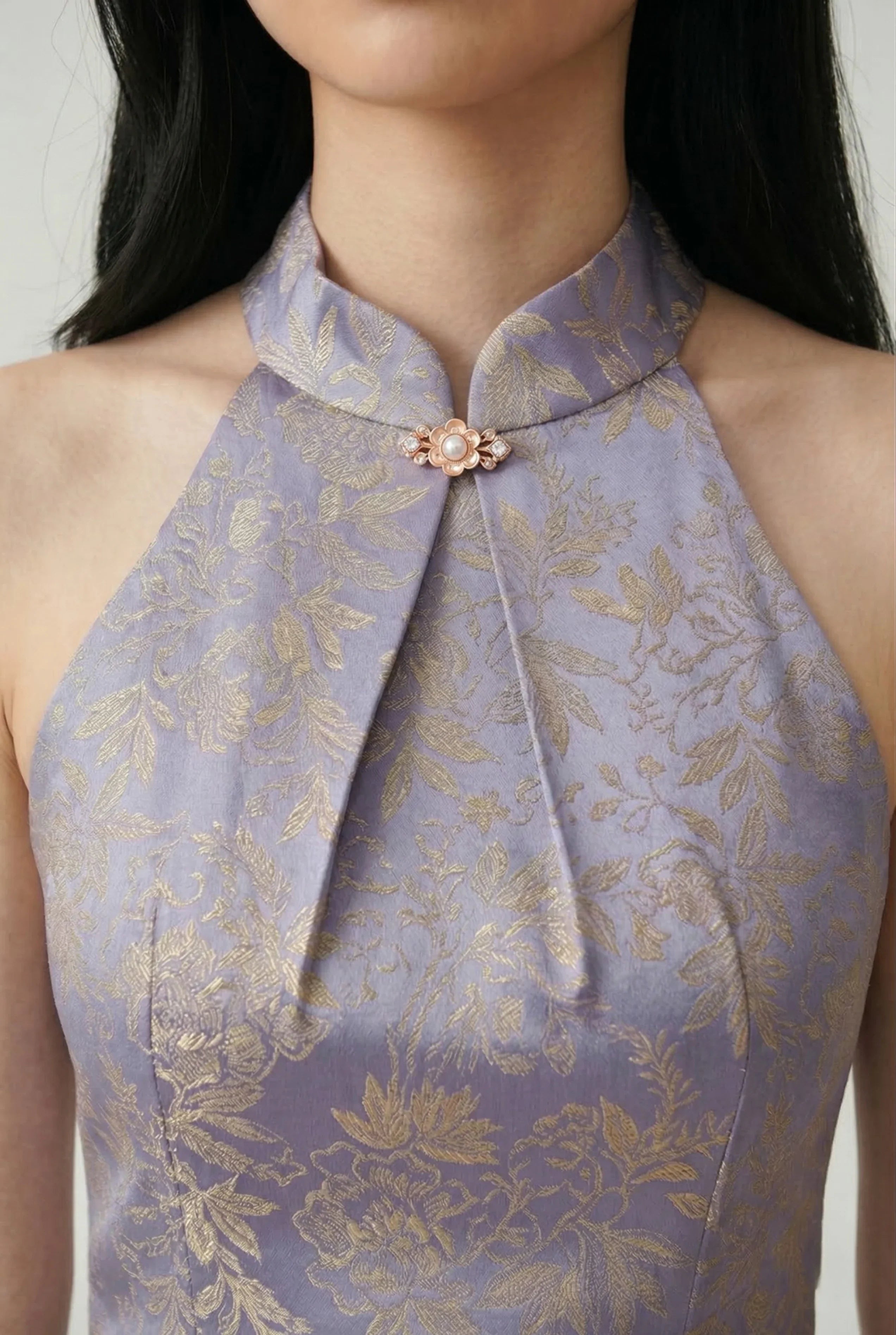 Close-up of the halter neck detail and gold-toned floral brocade fabric on a lavender Chinese dress.
