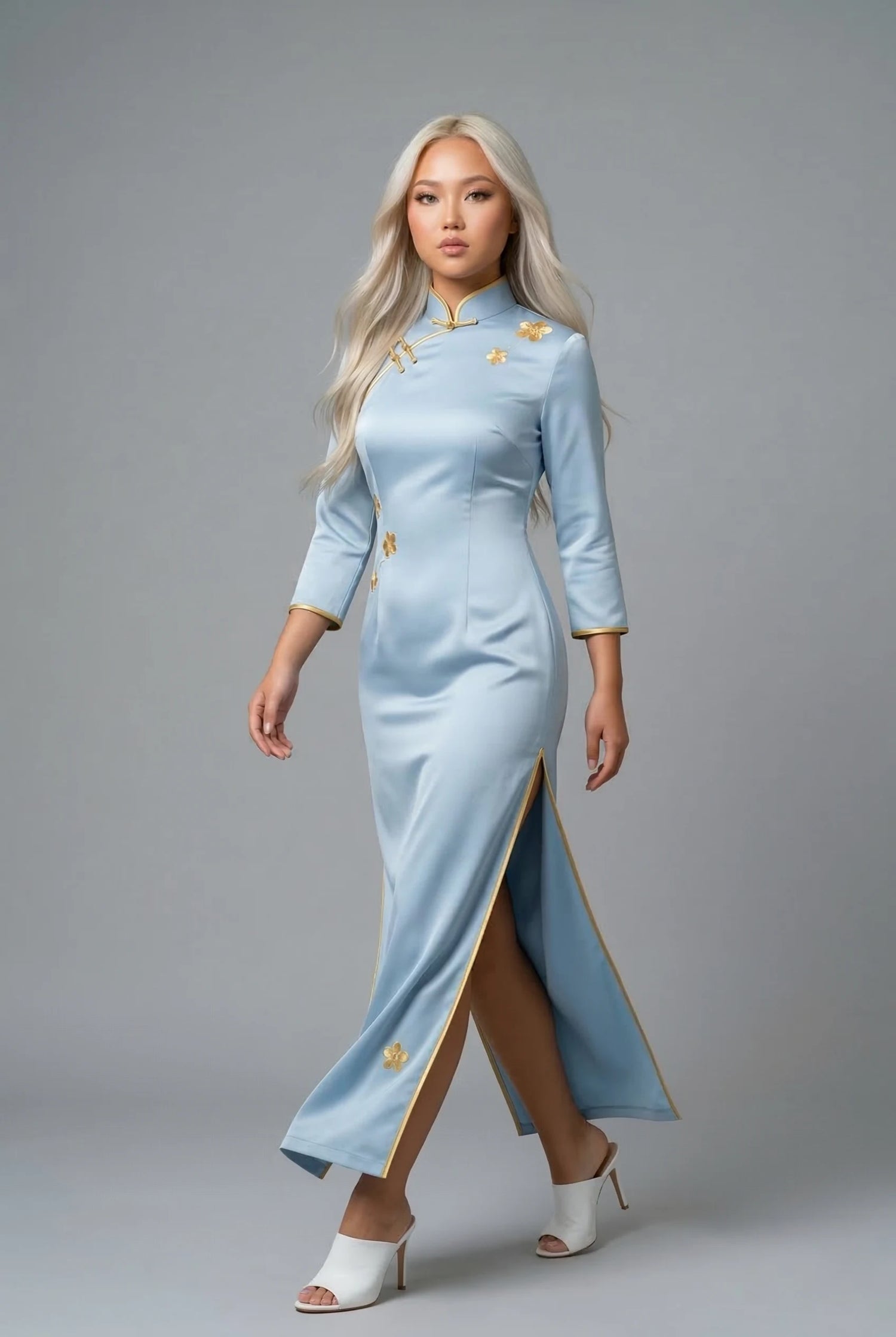 Long light blue silk qipao with gold thread embroidery and gold piping accents by Maison Hua, designed for formal evening sophistication