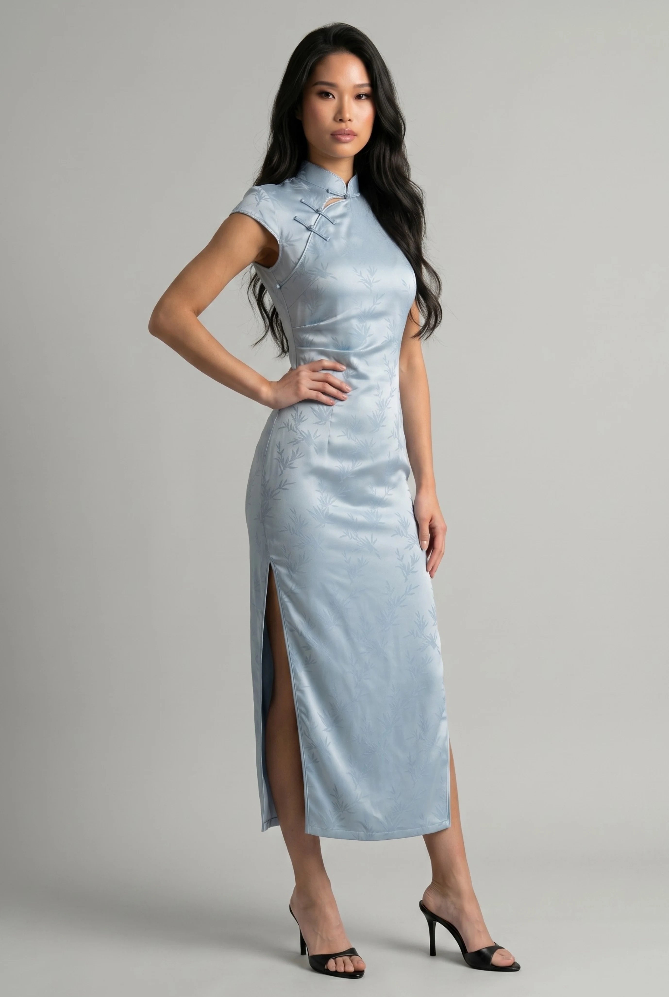 Three-quarter side profile view highlighting the high side slit on the light blue qipao dress