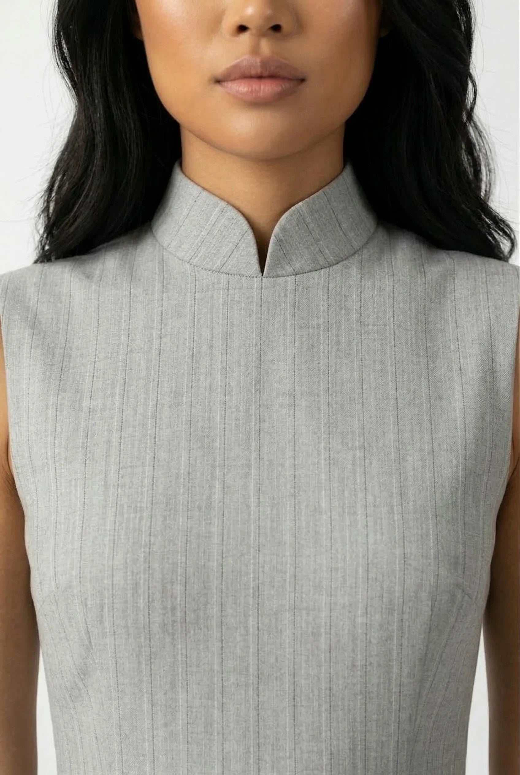 Close-up of the standing mandarin collar and high-quality grey textured fabric of a contemporary Qipao.