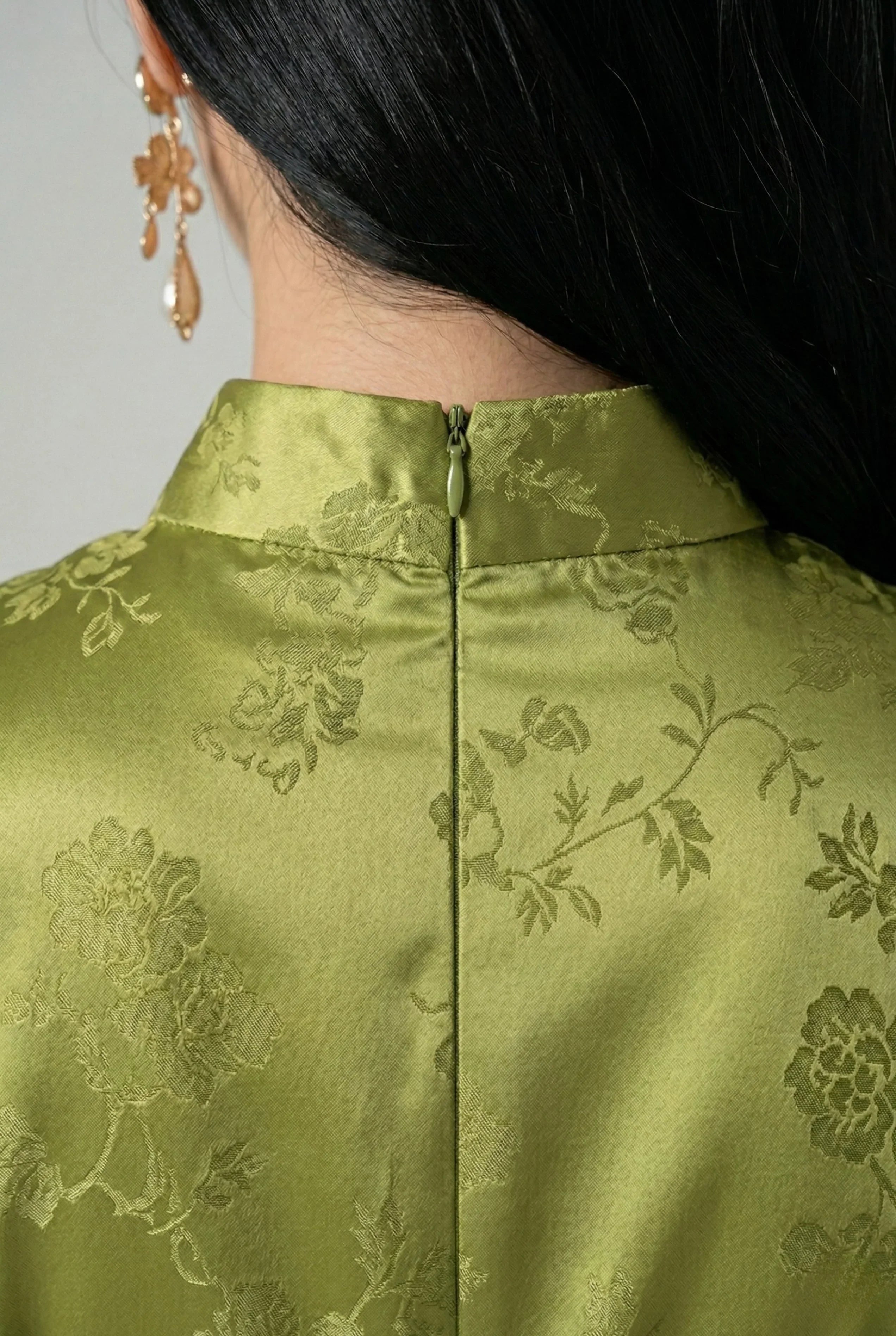 Detail of the back collar and invisible closure on an olive green cheongsam