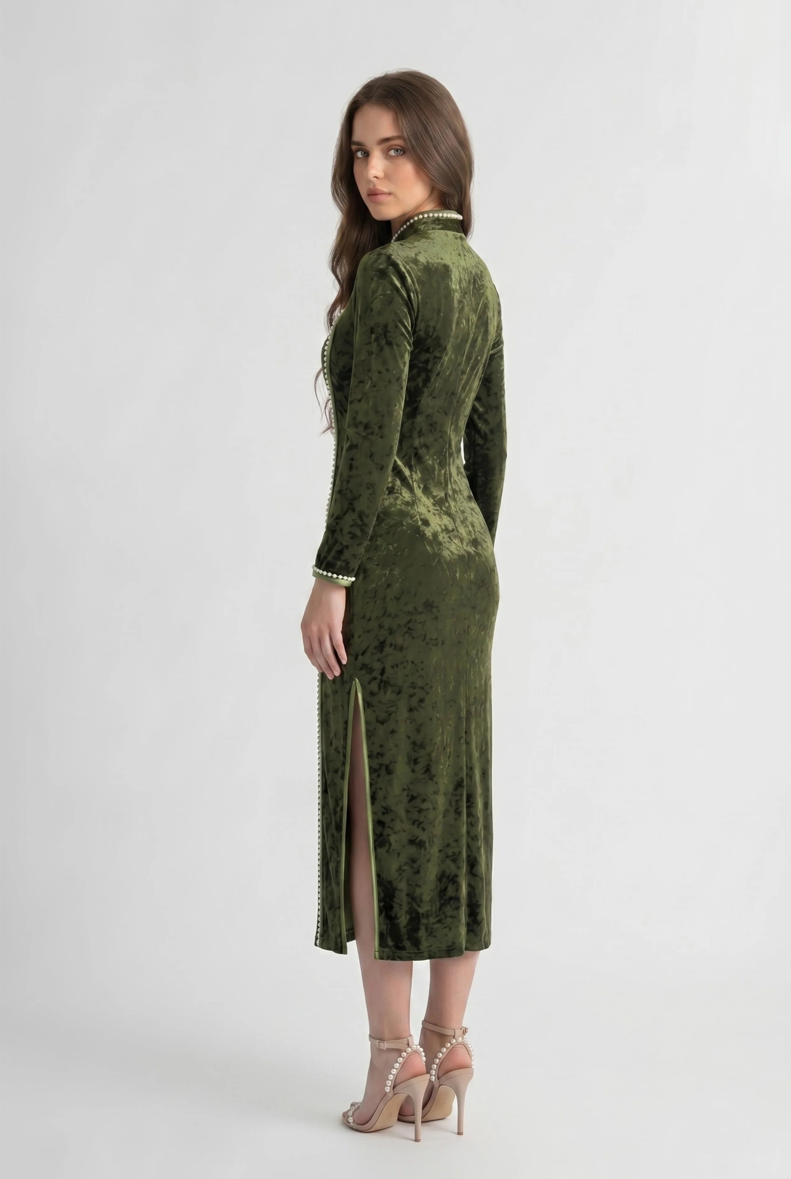 Three-quarter back profile view highlighting the form-fitting design and long sleeves of the olive velvet cheongsam