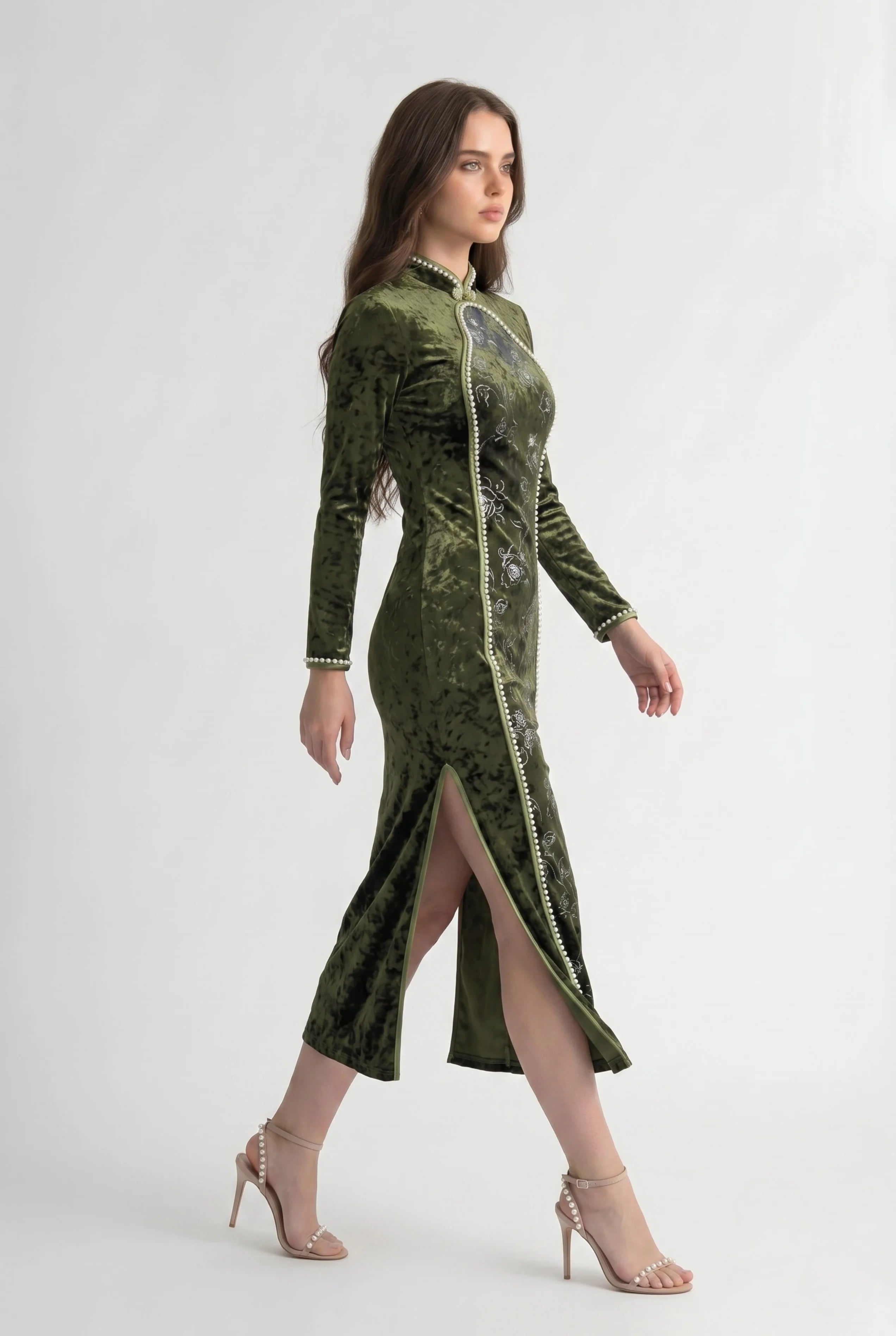 Full-body side profile view of a woman in stride wearing the olive velvet long sleeve cheongsam dress