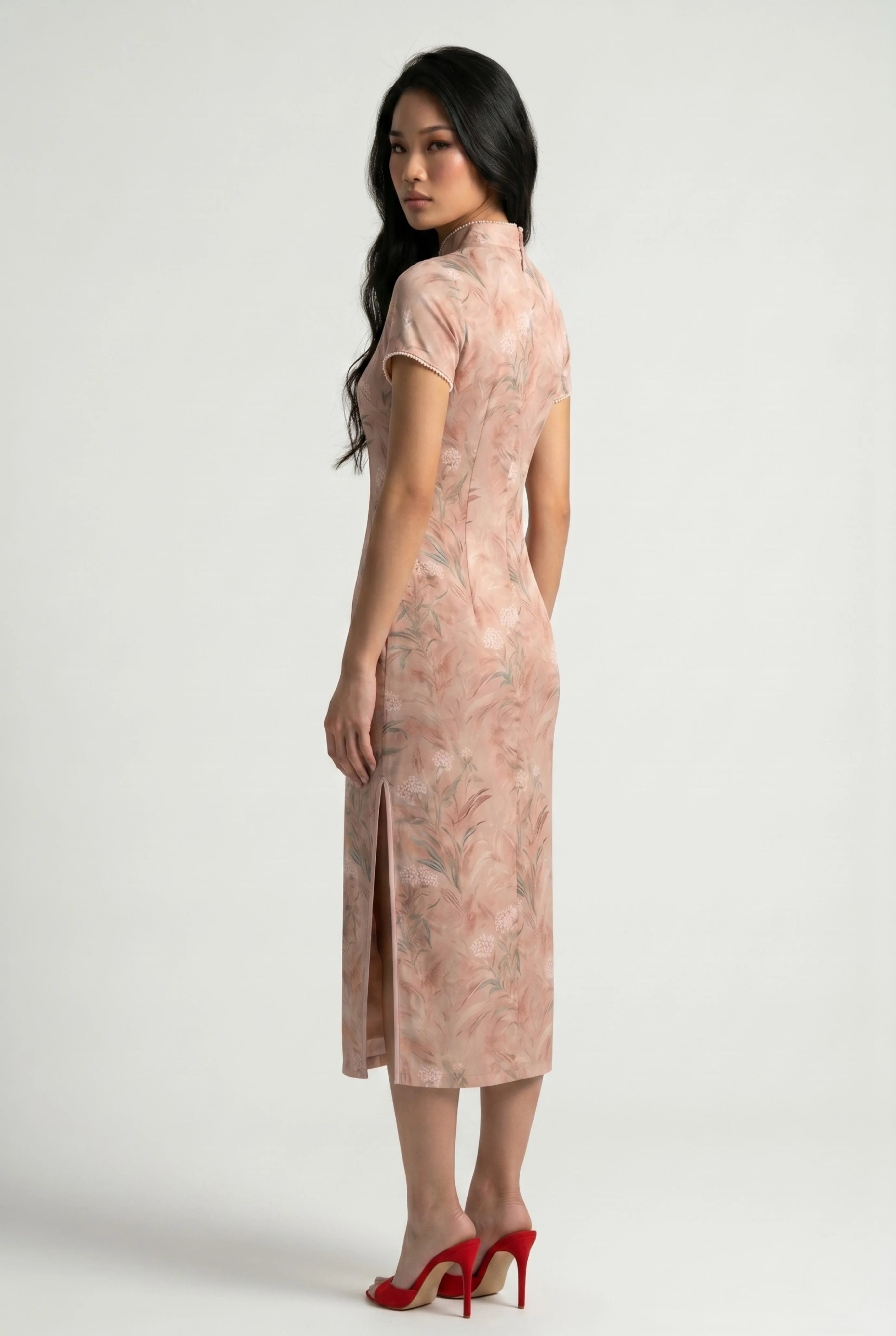 Three-quarter back profile view highlighting the form-fitting design and side slit of the pink floral cheongsam dress