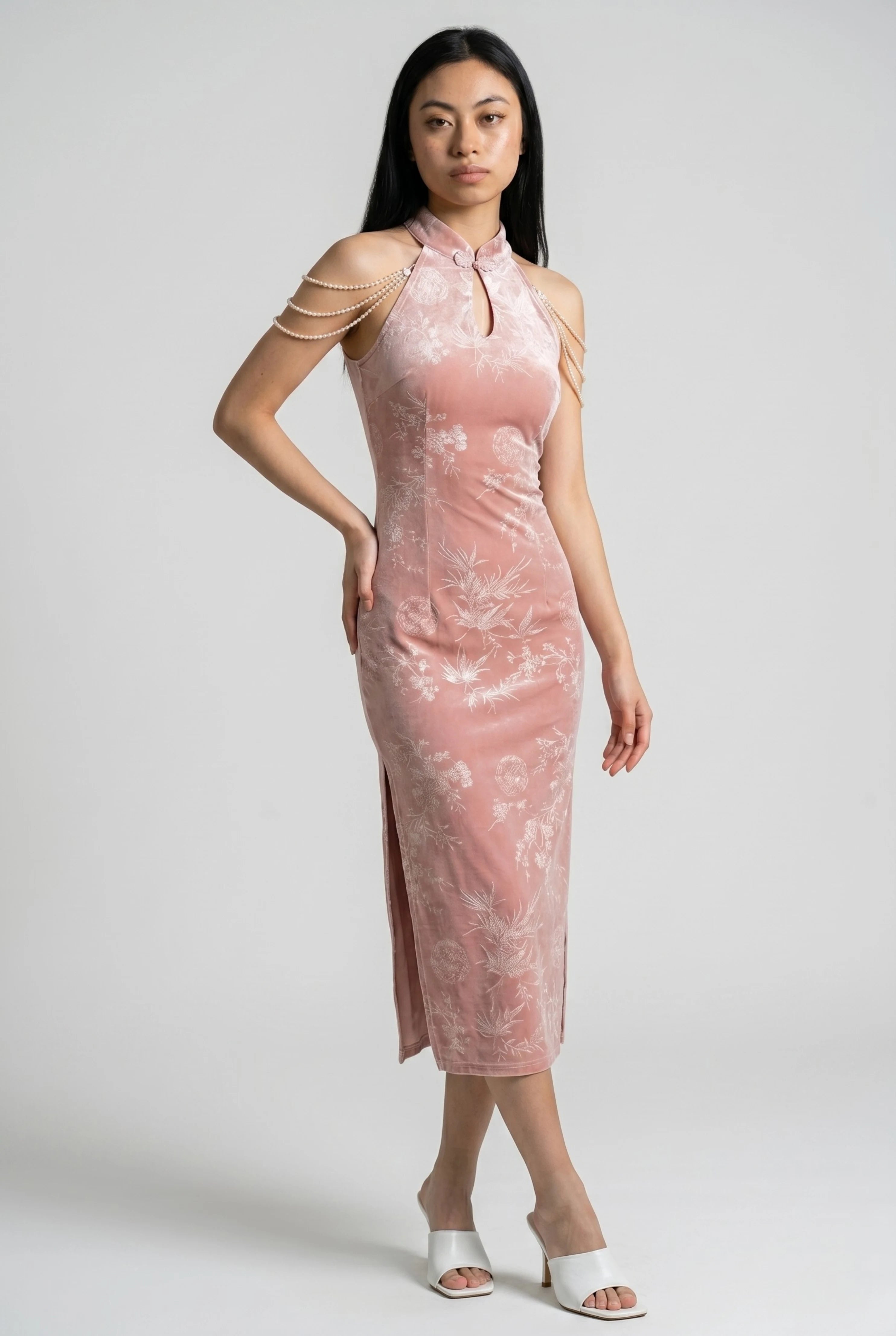 Three-quarter full-body view of the pink velvet cheongsam dress paired with white heels