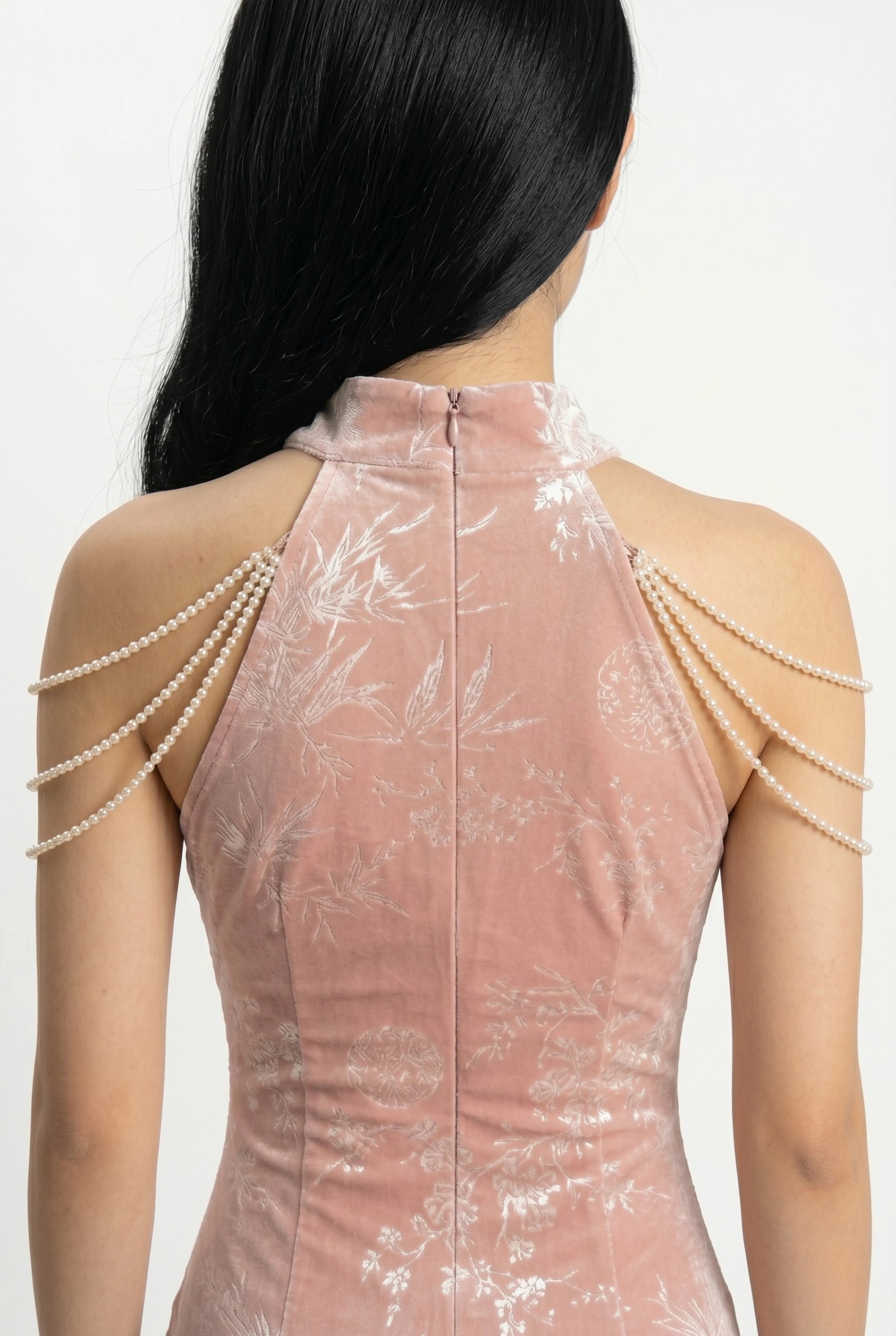 Close-up back view showing the zipper closure and the elegant draping of the pearl shoulder chains