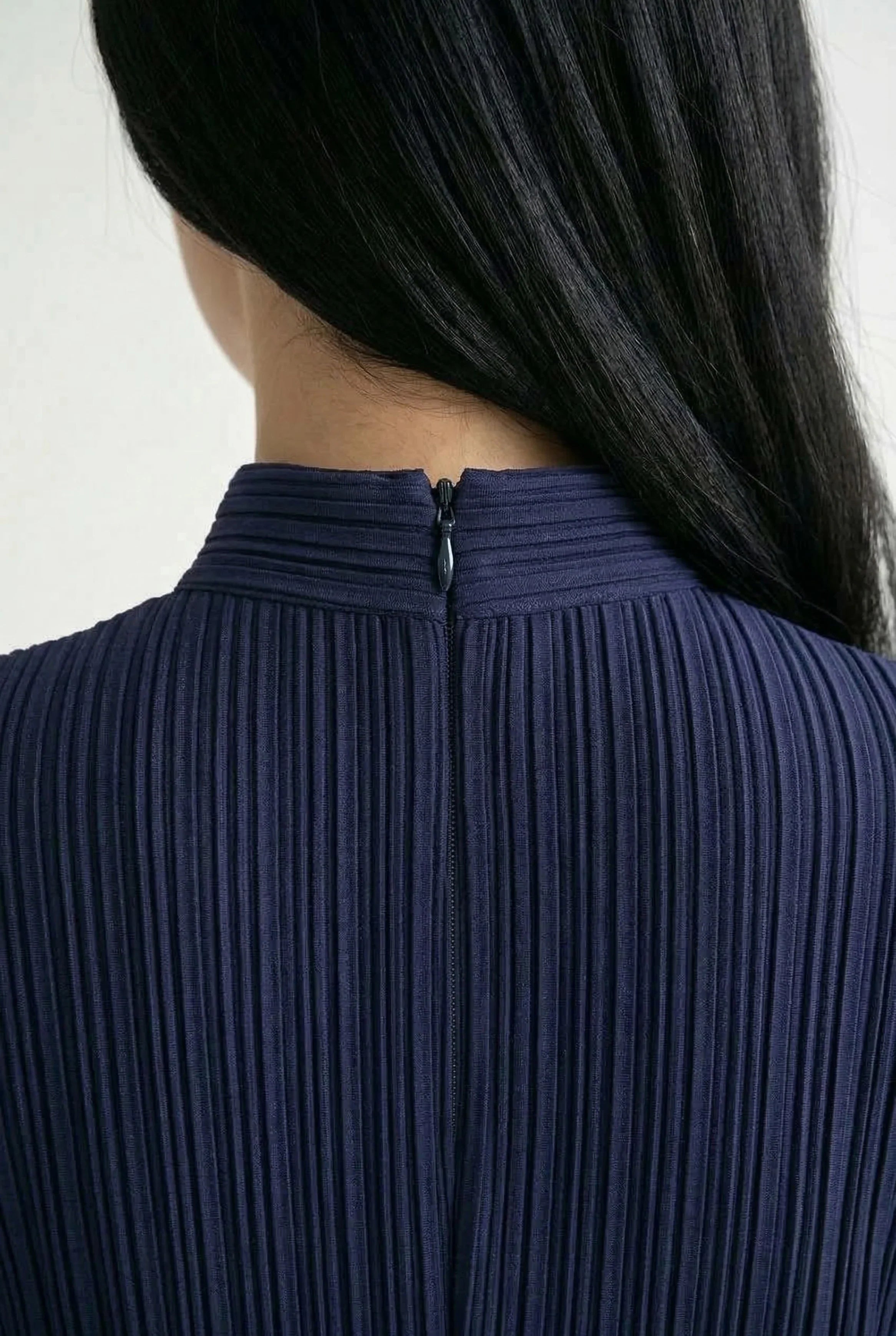 Close-up of the elegant high side slit on a purple Cheongsam dress, showing the fabric movement.
