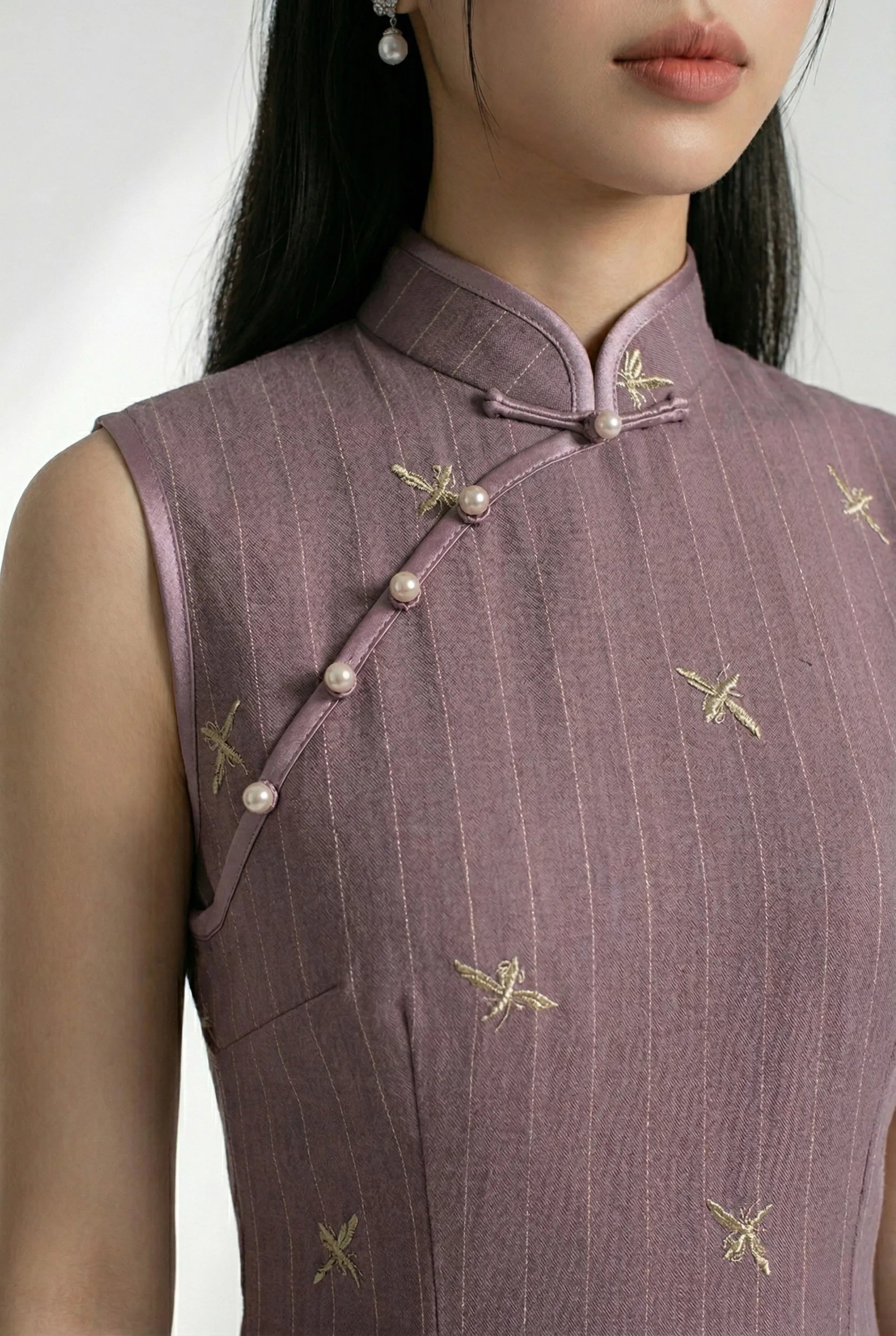 Close-up of the mandarin collar and traditional diagonal pearl buttons on the Chinese style purple dress.