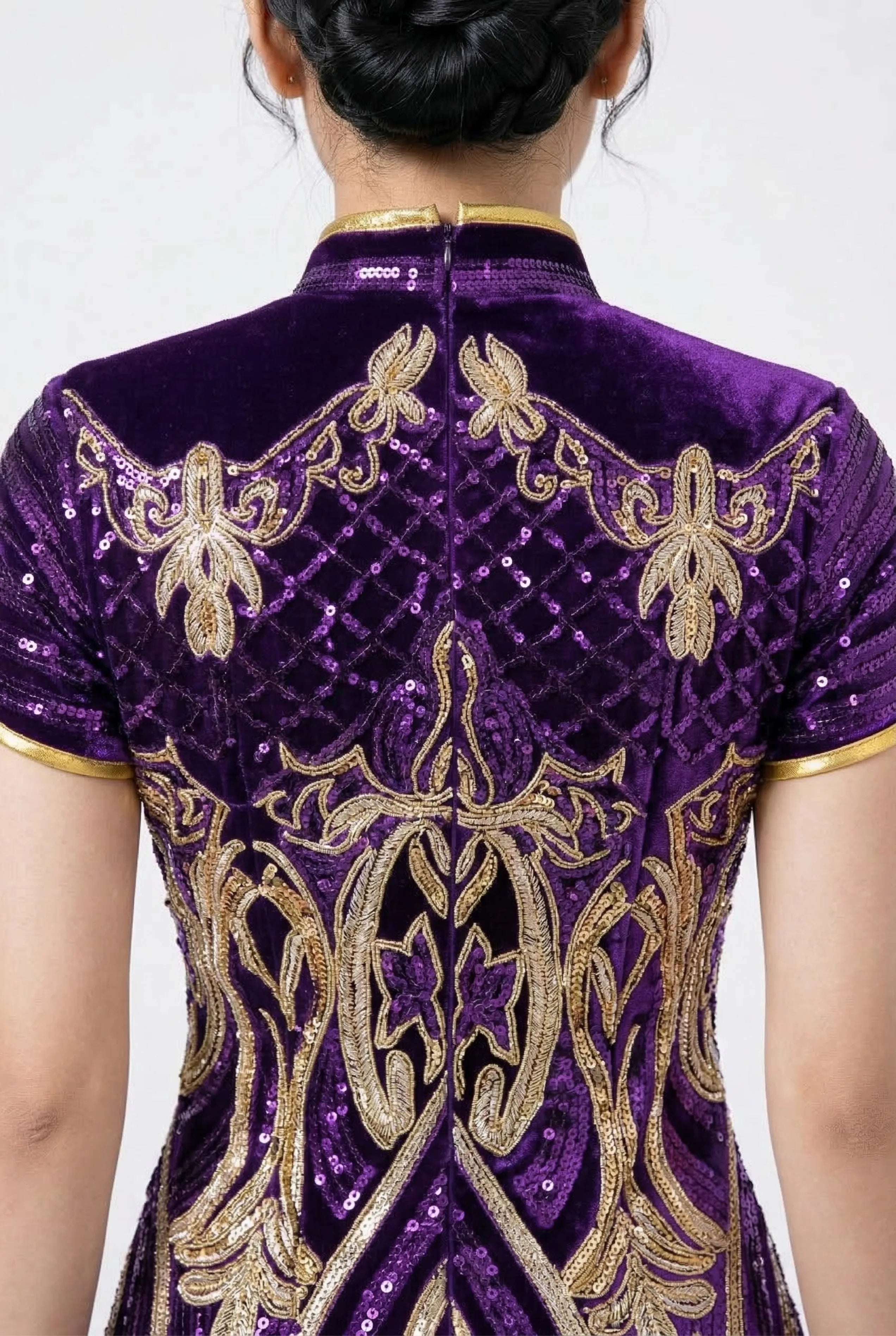 Detailed shot of the high mandarin collar and back embroidery on a purple sequin dress.