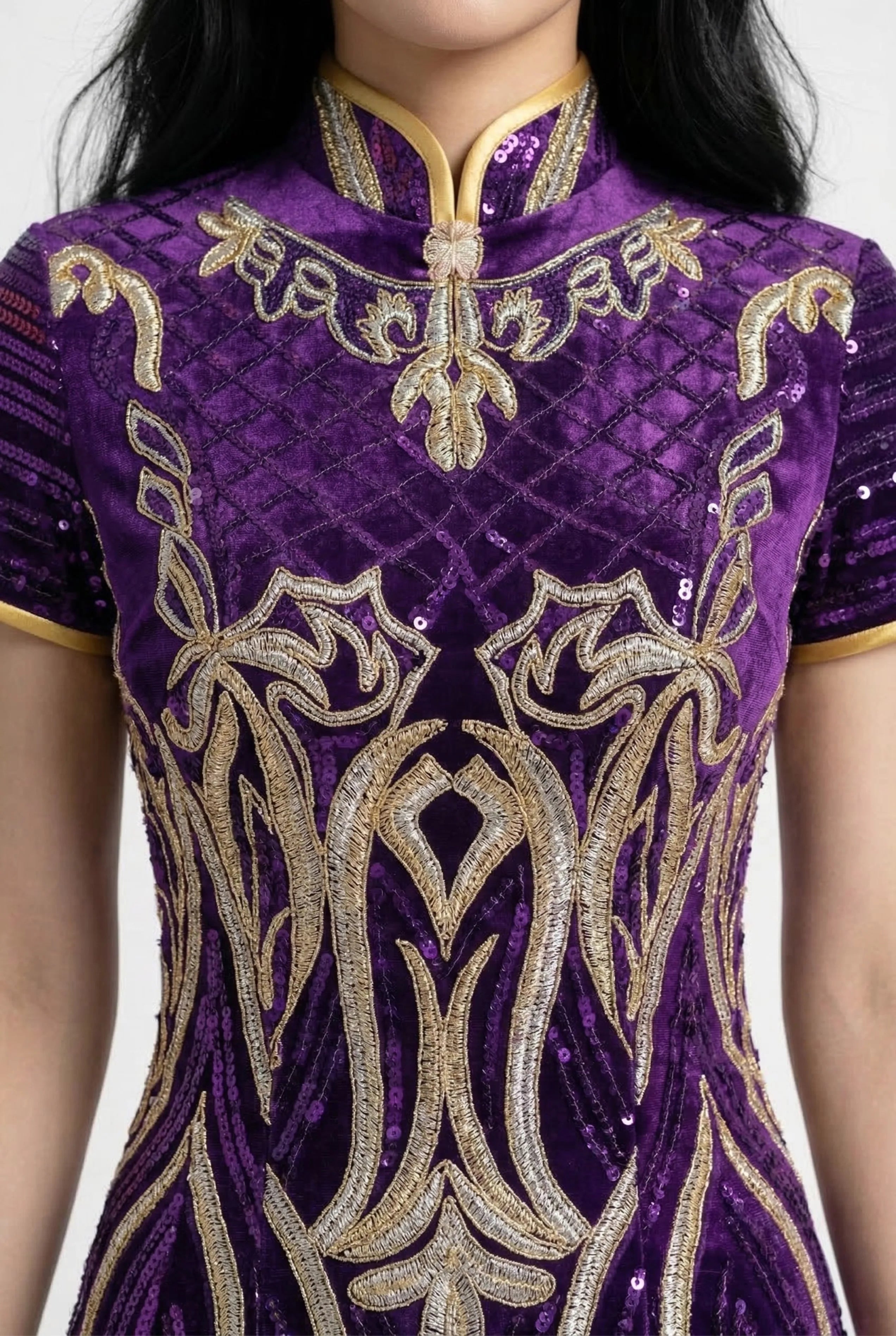 Close-up of the intricate gold embroidery and sequin texture on a purple Qipao.