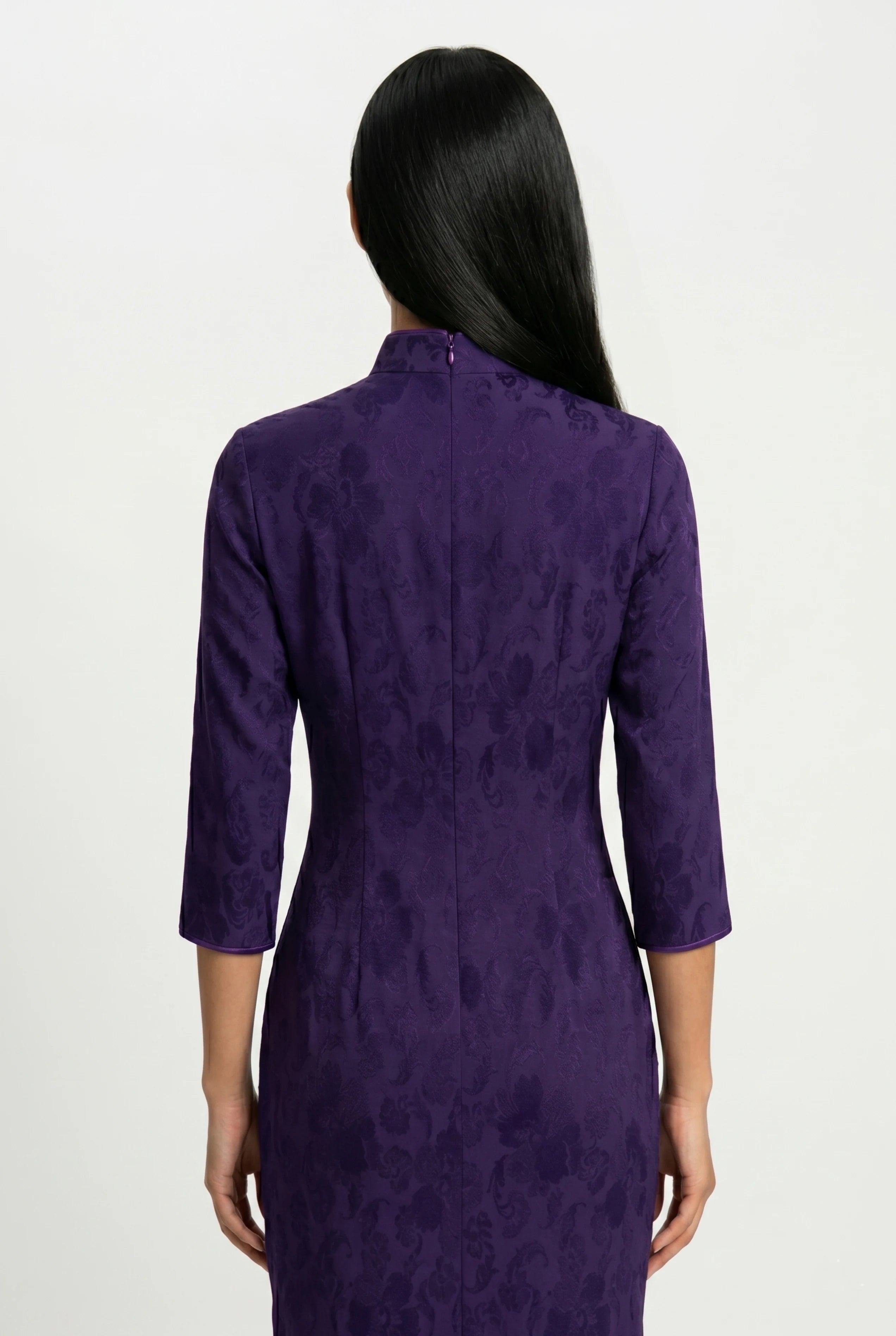 Close-up back view showing the hidden zipper closure and high collar structure of the purple velvet cheongsam