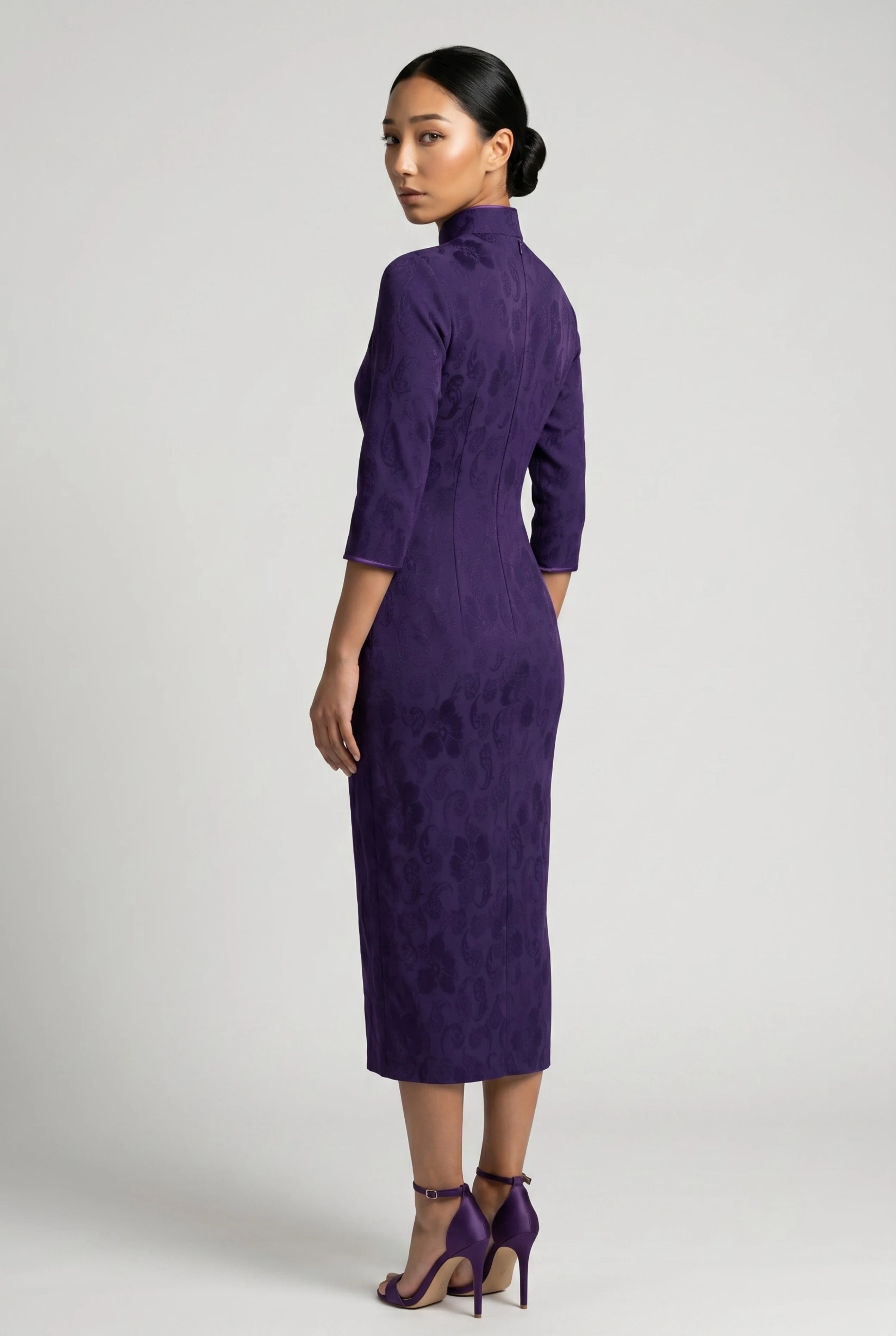 Three-quarter back profile view highlighting the sleek, form-fitting design of the purple velvet cheongsam