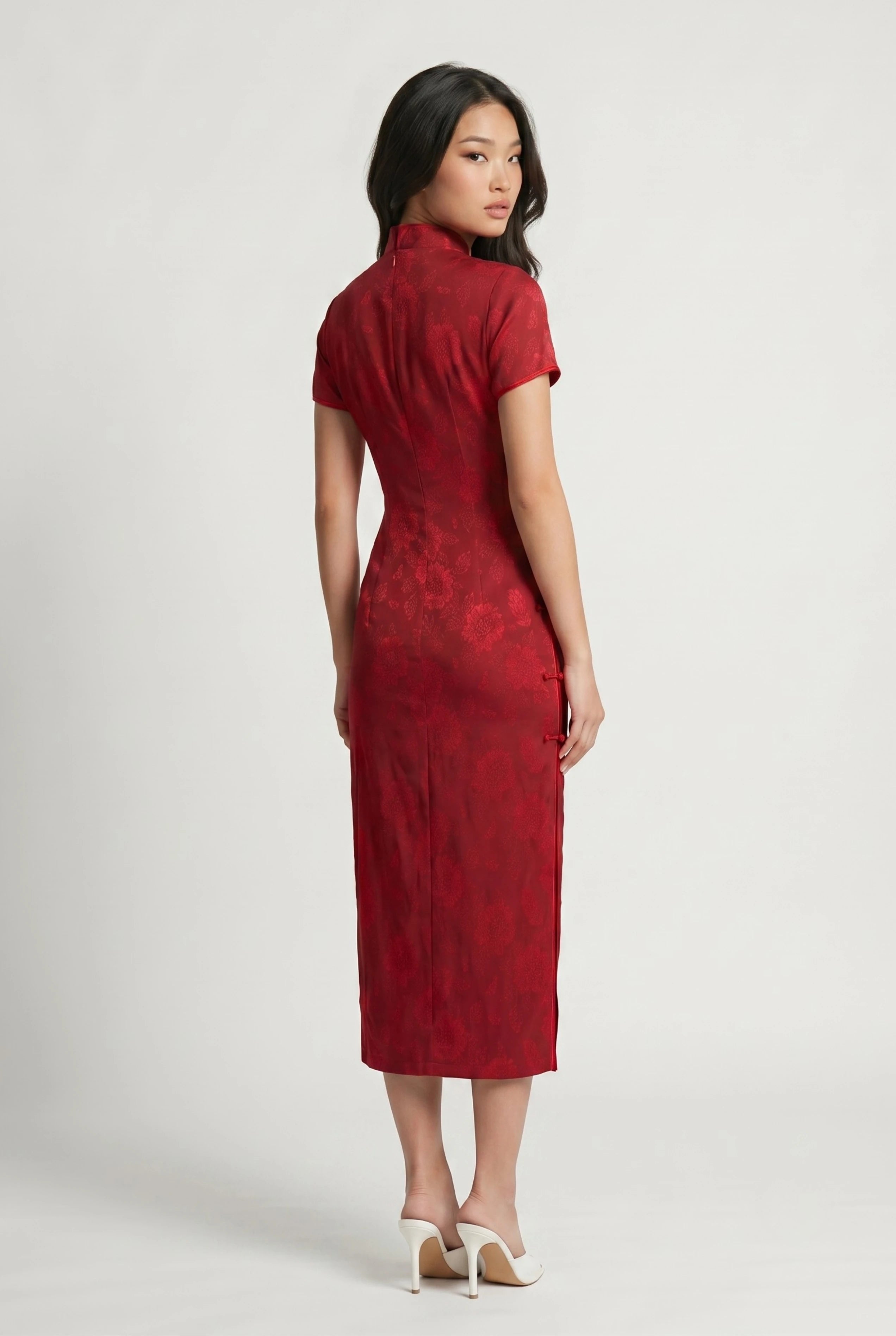 Three-quarter back profile view highlighting the sleek, form-fitting design of the long red cheongsam
